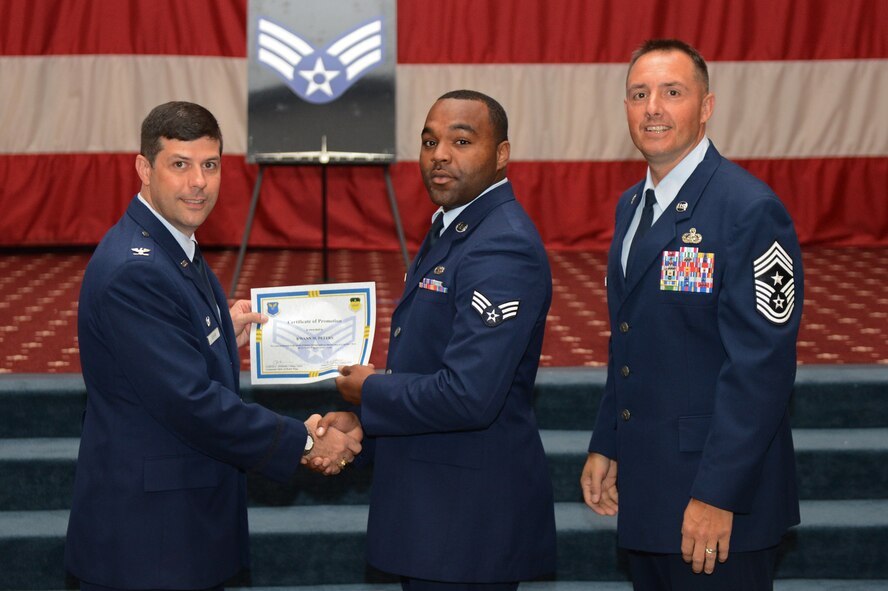Senior Airman Kwann Peters, from the 2nd Aircraft Maintenance Squadron, receives a certificate of promotion from Col. Andrew Gebara, 2nd Bomb Wing commander, and Chief Master Sgt. Curtis Storms, 2nd BW command chief, during the July Wing Promotion Ceremony on Barksdale Air Force Base, La., July 31, 2013. (U.S. Air Force photo/Senior Airman Micaiah Anthony)