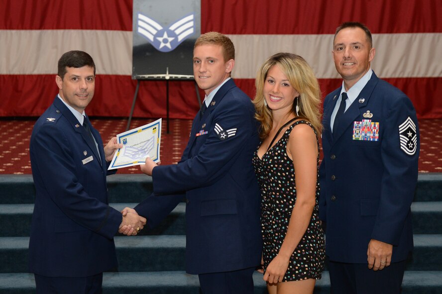 Senior Airman Steven Landreth, from the 2nd Aircraft Maintenance Squadron, receives a certificate of promotion from Col. Andrew Gebara, 2nd Bomb Wing commander, and Chief Master Sgt. Curtis Storms, 2nd BW command chief, during the July Wing Promotion Ceremony on Barksdale Air Force Base, La., July 31, 2013. (U.S. Air Force photo/Senior Airman Micaiah Anthony)