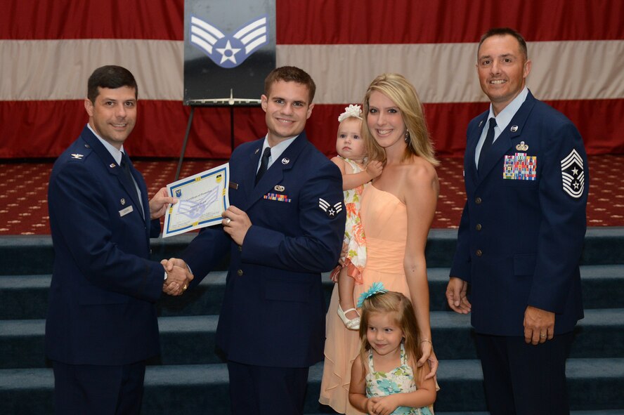 Senior Airman Joshua Hyder, from the 2nd Aircraft Maintenance Squadron, receives a certificate of promotion from Col. Andrew Gebara, 2nd Bomb Wing commander, and Chief Master Sgt. Curtis Storms, 2nd BW command chief, during the July Wing Promotion Ceremony on Barksdale Air Force Base, La., July 31, 2013. (U.S. Air Force photo/Senior Airman Micaiah Anthony)