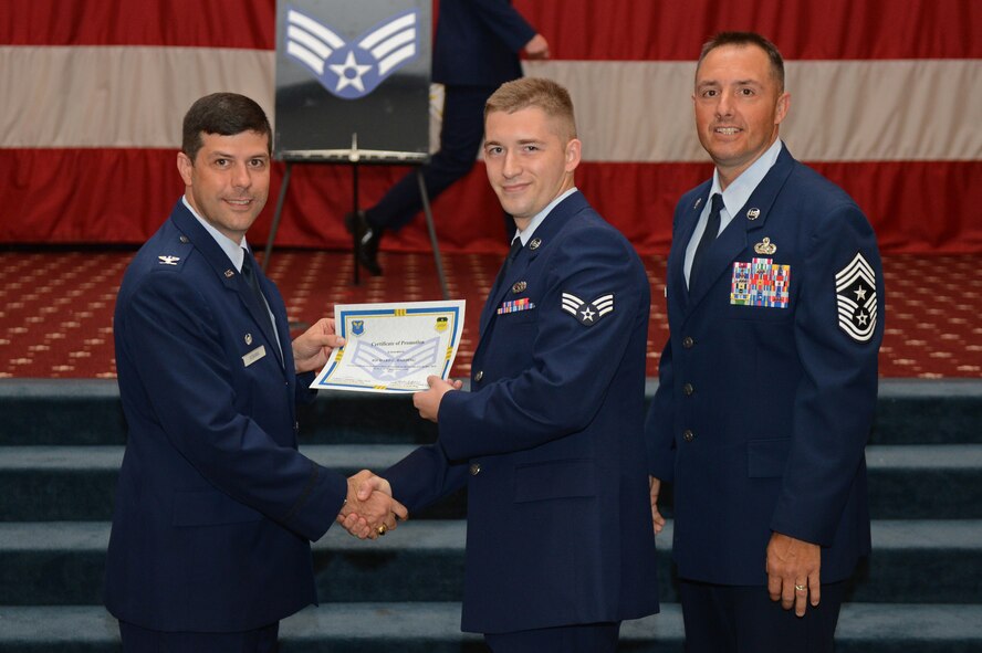 Senior Airman Richard Harding, from the 2nd Aircraft Maintenance Squadron, receives a certificate of promotion from Col. Andrew Gebara, 2nd Bomb Wing commander, and Chief Master Sgt. Curtis Storms, 2nd BW command chief, during the July Wing Promotion Ceremony on Barksdale Air Force Base, La., July 31, 2013. (U.S. Air Force photo/Senior Airman Micaiah Anthony)