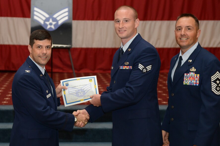 Senior Airman Dylan Drake, from the 2nd Aircraft Maintenance Squadron, receives a certificate of promotion from Col. Andrew Gebara, 2nd Bomb Wing commander, and Chief Master Sgt. Curtis Storms, 2nd BW command chief, during the July Wing Promotion Ceremony on Barksdale Air Force Base, La., July 31, 2013. (U.S. Air Force photo/Senior Airman Micaiah Anthony)