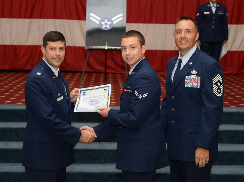 Airman 1st Class Kyle Reese, from the 2nd Maintenance Squadron, receives a certificate of promotion from Col. Andrew Gebara, 2nd Bomb Wing commander, and Chief Master Sgt. Curtis Storms, 2nd BW command chief, during the July Wing Promotion Ceremony on Barksdale Air Force Base, La., July 31, 2013. (U.S. Air Force photo/Senior Airman Micaiah Anthony)