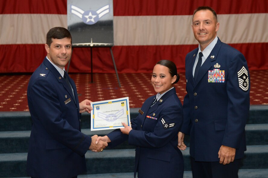 Airman 1st Class Christina Fritz, from the 2nd Aerospace Medicine Squadron, receives a certificate of promotion from Col. Andrew Gebara, 2nd Bomb Wing commander, and Chief Master Sgt. Curtis Storms, 2nd BW command chief, during the July Wing Promotion Ceremony on Barksdale Air Force Base, La., July 31, 2013. (U.S. Air Force photo/Senior Airman Micaiah Anthony)