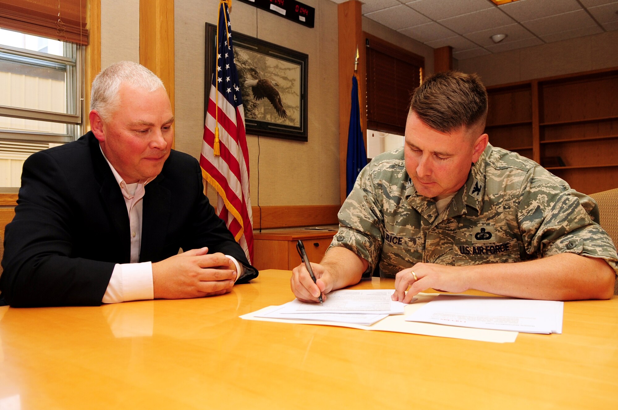 U.S. Air Force Col. Larry Rice, 354th Mission Support Group commander, signs the first housing lease agreement with Josh Crawford, Corvias Military Living program manager, August 1, 2013 Eielson Air Force Base, Alaska. Corvias will hold Housing Privatization Town Hall meetings at 5 and 7 p.m. Aug.6 at the base theater to discuss the near-term way ahead. (U.S. Air Force photo by Airman 1st Class Lauren-Taylor Levin/Released)
