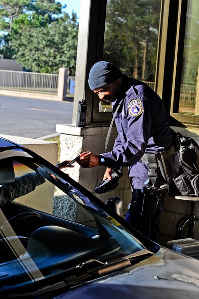 Officer Darrell Bentham, a Hurlburt Field Security Forces guard checks identification cards at the Main Gate on Hurlburt Field, Fla.  A new policy has taken effect that allows Department of Defense cardholders to vouch for non-DoD cardholders to get on base during the hours of 5 a.m. to 10 p.m.(U.S. Air Force photo/Airman 1st Class Christopher Callaway)   