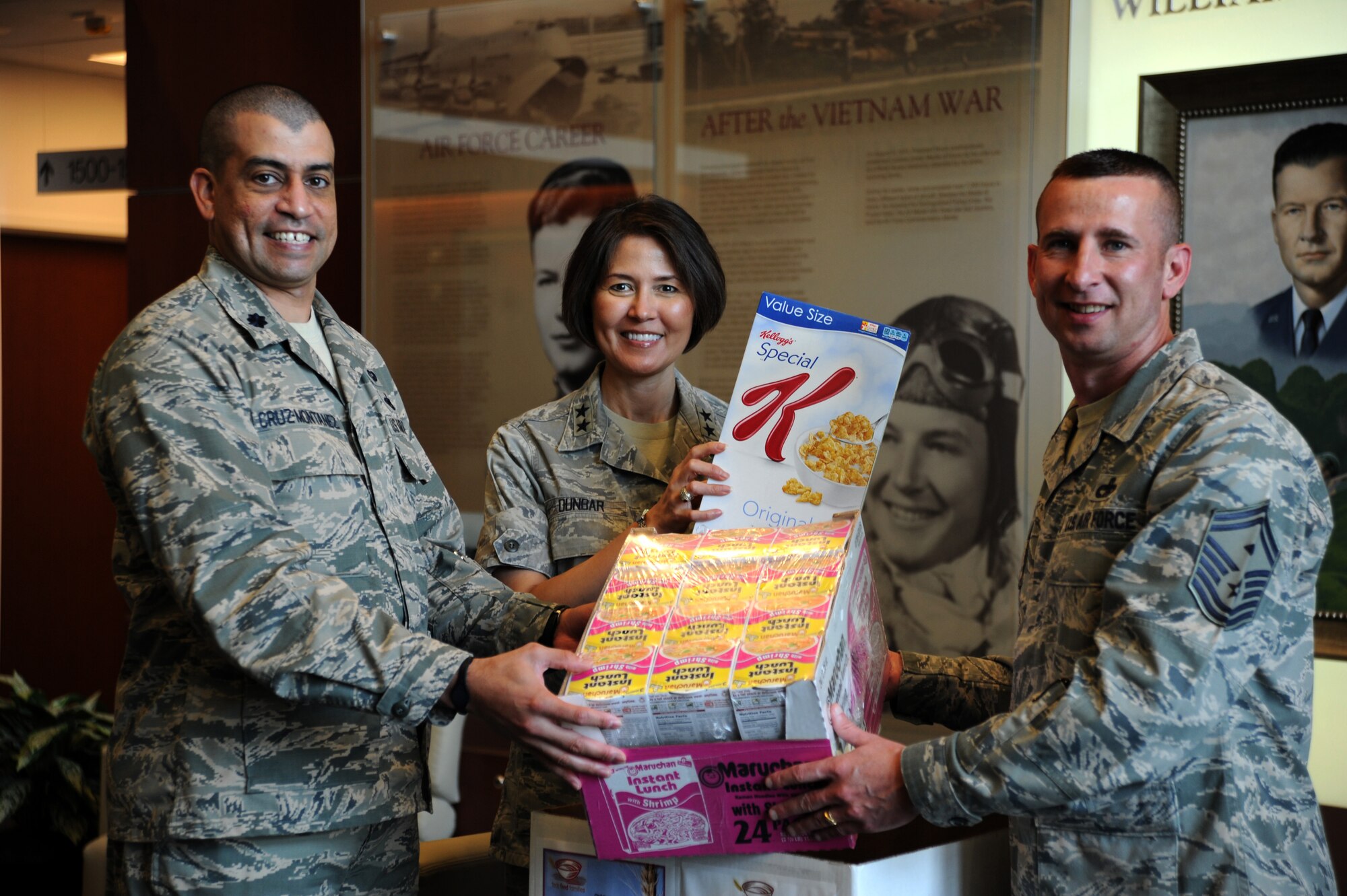 (Center) Air Force District of Washington Commander Maj. Gen. Sharon K. G. Dunbar, Lt. Col. Felix Cruz-Montanez, AFDW Feds Feeds Families program coordinator, and Senior Master Sgt. Johnny Hamm, AFDW first sergeant, make a nonperishable donation to the Feds Feeds Families collection box on Joint Base Andrews, Md., Aug. 2, 2013. Donations can be made across the installation until Aug. 28, 2013. (U.S. Air Force photo by Tech. Sgt. Tammie Moore)