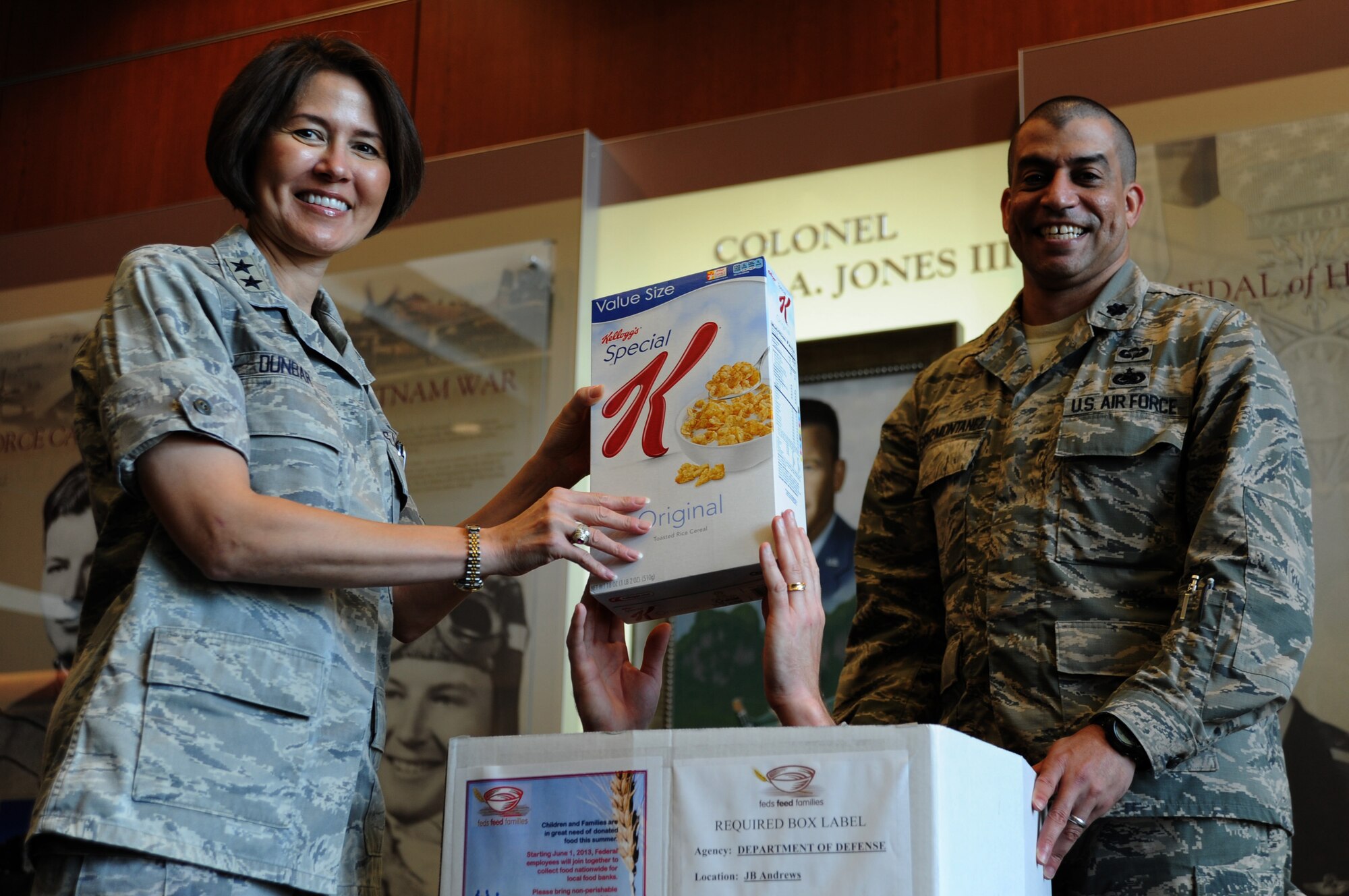 Air Force District of Washington Commander Maj. Gen. Sharon K. G. Dunbar and Lt. Col. Felix Cruz-Montanez, AFDW Feds Feeds Families program coordinator, make a nonperishable food donation at Joint Base Andrews, Md., Aug. 2, 2013. Feds Feed Families is an annual Department of Defense and National Capital Region initiative to raise awareness about hunger and collect food to benefit local food banks. So far this year, members of Team Andrews and AFDW donated 1,700 pounds of food to the program.  (U.S. Air Force photo by Tech. Sgt. Tammie Moore)