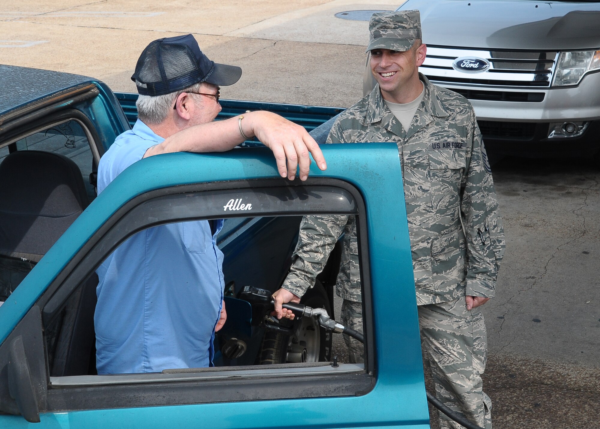 Master Sgt. Shawn Andrews, 14th Operations Group First Sergeant, explains Operation WarmHeart to a DynCorp employee while pumping gas bought by the First Sergeants Council on July 26. The First Sergeants Council hung out by the Gas Pumps outside of the Shoppette and surprised numerous individuals by offering to pay for a portion of their gas. While many people left smiling, one surprised guest left with tears in her eyes claiming it was “the nicest thing to happen to her all week”. (U.S. Air Force Photo/ Airman 1st Class Stephanie Englar)
