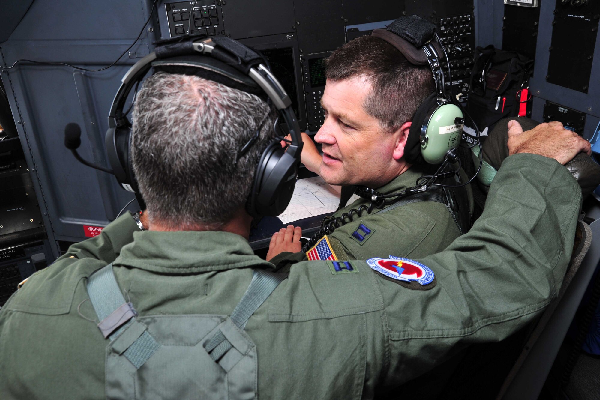 Capts. Michael Anderson and Christopher Harris (right), 53rd Weather Reconnaissance Squadron navigators, discuss possible flight routes through the remnants of Dorian July 29, 2013. This particular mission served as an excellent training opportunity for Harris, who was being mentored during the storm flight by Anderson. The Hurricane Hunters flew a low-level investigation into the tropical wave to gather storm data used by the National Hurricane Center to determine whether Dorian was breaking up or reforming into a more intensified storm. (U.S. Air Force photo/Tech. Sgt. Ryan Labadens)