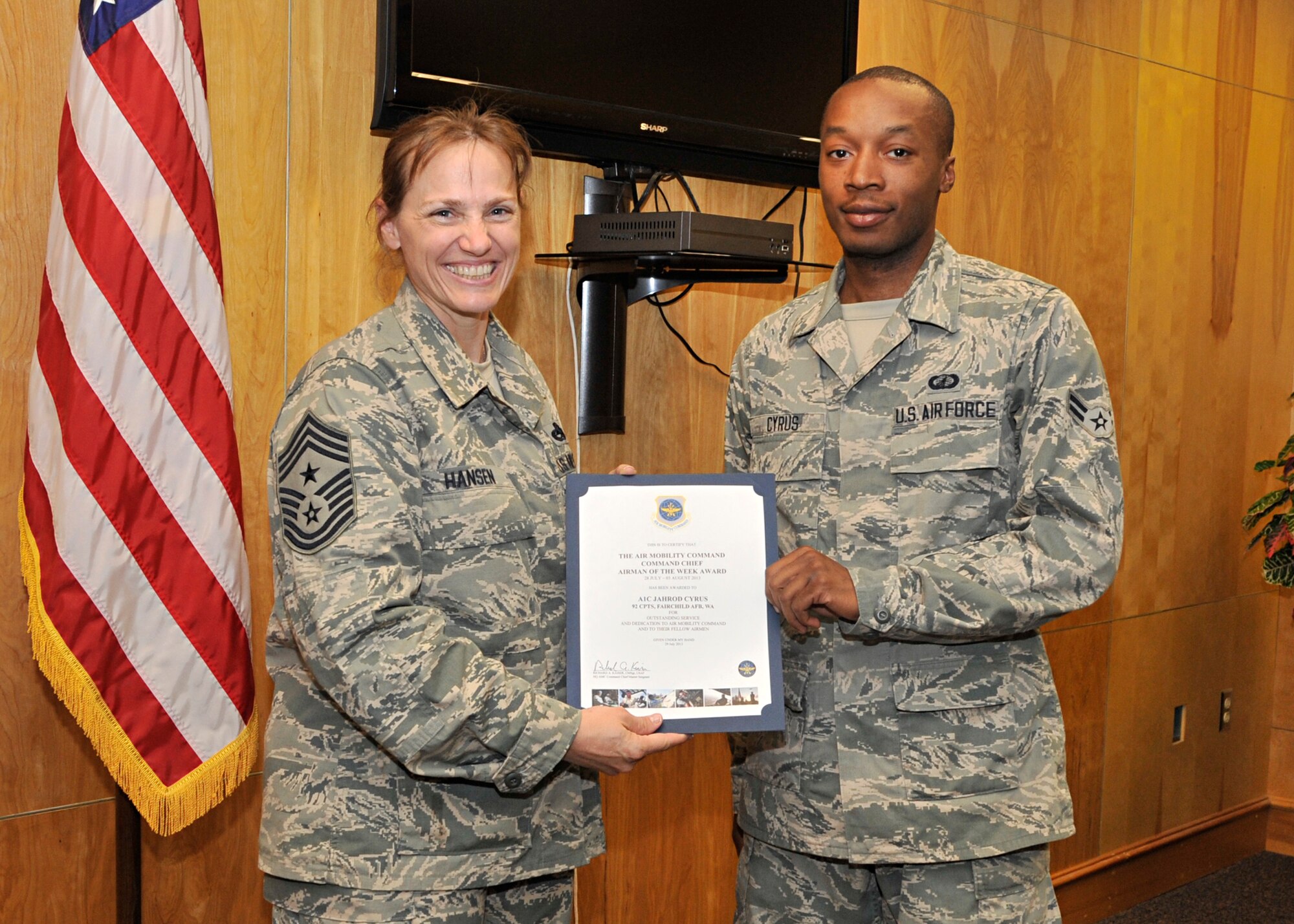 Chief Master Sergeant Wendy Hansen, 92nd Air Refueling Wing command chief, presents Airman 1st Class Jahrod Cyrus with a certificate August 1, 2013. Cyrus was presented with the Air Mobility Command, Command Chief Airman of the Week Award for the week of July 28 through Aug. 3, 2013. (U.S. Air Force photo by Senior Airman Mary O’Dell/Released)