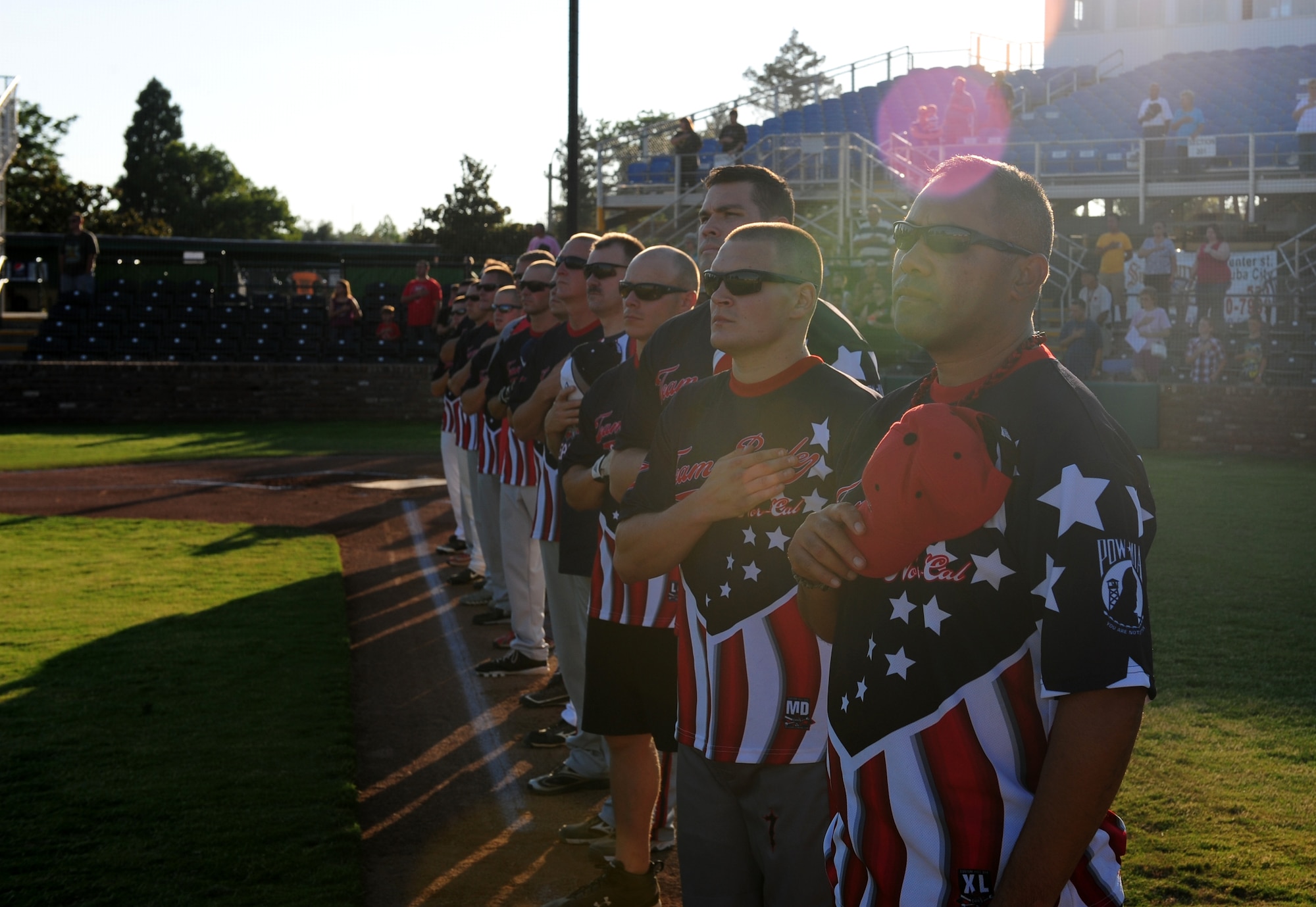 Beale Airmen pay repect as the National Anthem is played before their contest with the Marysville Gold Sox at Appeal Democrat Park in Marysville Calif., on July 31, 2013. The Beale All-Star softball team defeated the Gold Sox 8-4. (U.S. Air Force photo by Airman 1st Class Bobby Cummings/Released)