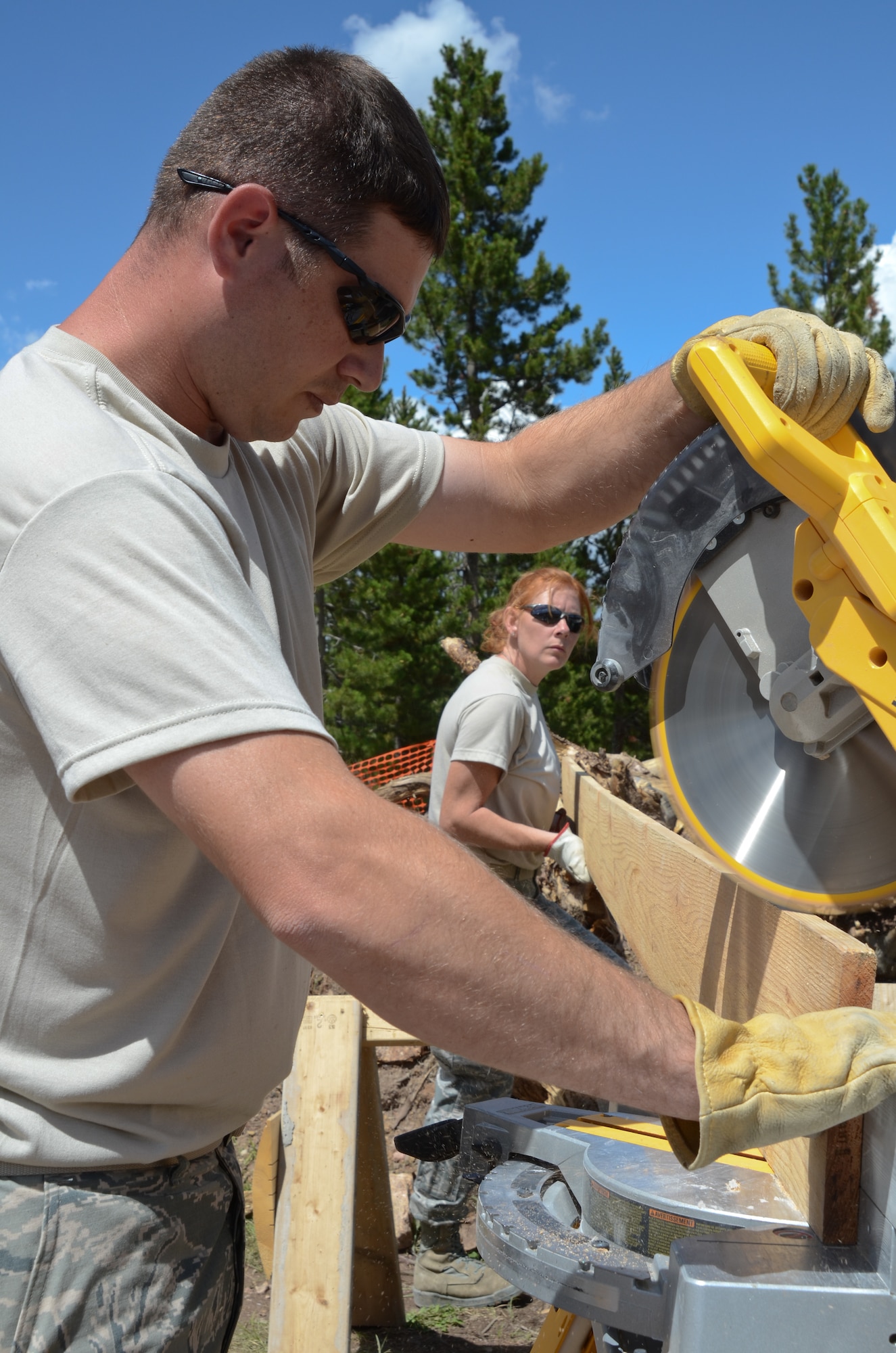 U.S. Air Force Staff Sgt. Anthony Anderson (front) and Senior Airman Krista Abernethy with the Missouri Air National Guard, 139th Civil Engineering Squadron, cut a board for the groomer building at Snow Mountain Ranch, near Winter Park, Colo., July 30, 2013.  The Airmen provided assistance with the construction and maintenance of various structures throughout the camp during an Innovative Readiness Training mission.   (U.S. Air National Guard photo by Senior Airman Patrick P. Evenson/Released)