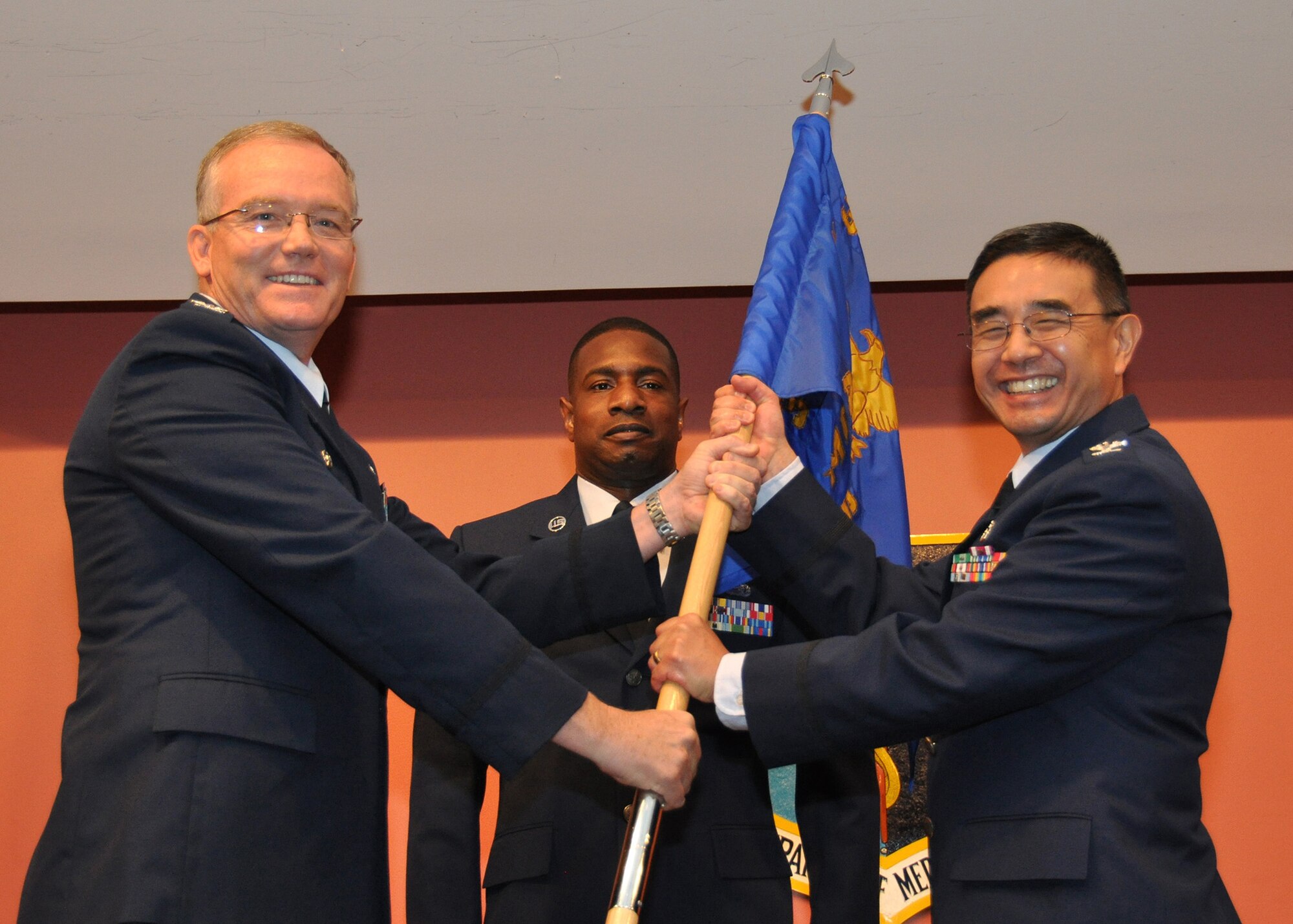 TRAVIS AIR FORCE BASE, Calif. -- Col. Kenneth Furukawa accepts the 349th Aeromedical Squadron guidon from Col. Kurt Lambert, 30th Medical Group commander, during a change of command ceremony held here July 28th. Col. Furukawa, previously the B-flight leader of the physicians flight, took command of the unit from Col. Terese LeFrancois. (U.S. Air Force photo/SMSgt Robert Wade)