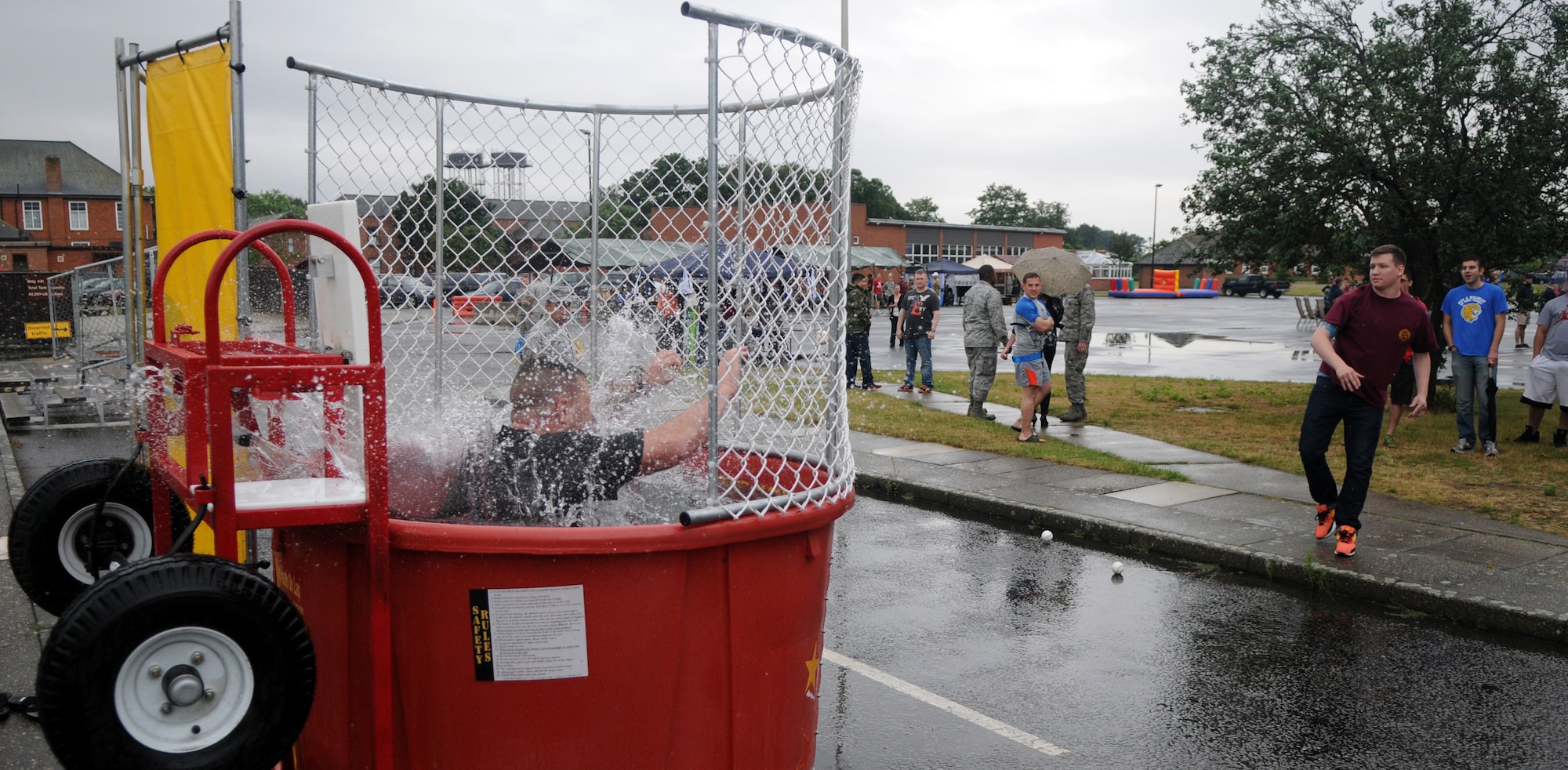 U.S. Air Force Maj. Mark Rardin, 100th Maintenance Squadron commander, splashes down into a dunk tank pool after a solid throw from U.S. Air Force Senior Airman Ross Allbaugh, 352nd Special Operations Group crew chief from Cleveland, Ohio, at the Unaccompanied Airmen Appreciation Day Aug. 2, 2013, on RAF Mildenhall. Representatives from all levels of leadership on RAF Mildenhall took turns in the dunk tank’s seat, allowing Airmen to take turns dropping them in the tank. The Unaccompanied Airmen Appreciation Day allowed Airmen serving at RAF Mildenhall without families to enjoy a day of leisure activities orchestrated specifically for them as a show of appreciation for their unique circumstances. (U.S. Air Force photo by Staff Sgt. Austin M. May/Released)