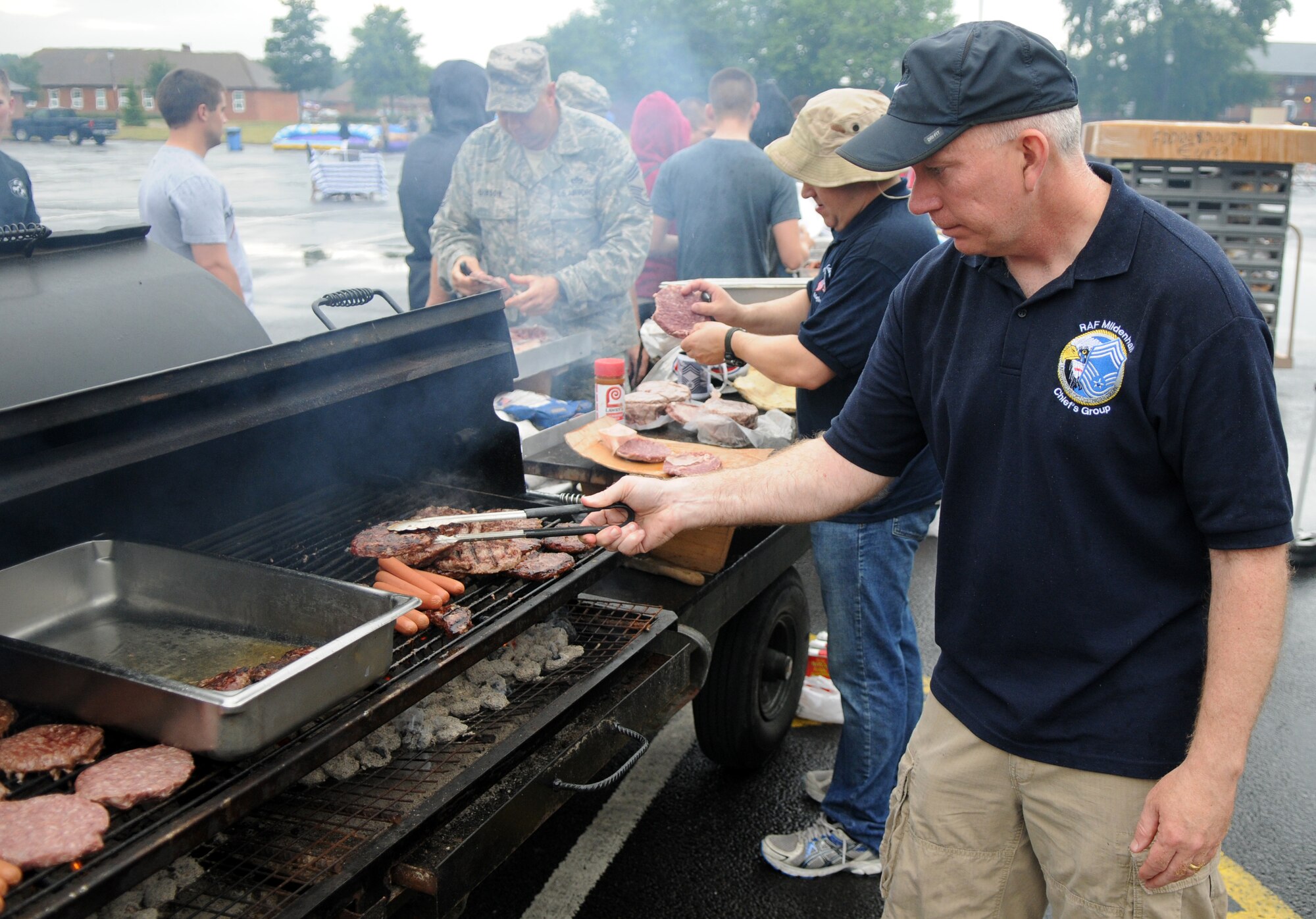 U.S. Air Force Chief Master Sgt. Daniel Trahan, 100th Security Forces Squadron enlisted manager, cooks hamburgers and hot dogs at the Unaccompanied Airmen Appreciation Day Aug. 2, 2013, on RAF Mildenhall. The event allowed Airmen serving at RAF Mildenhall without families to enjoy a day of leisure activities orchestrated specifically for them as a show of appreciation for their unique circumstances. (U.S. Air Force photo by Staff Sgt. Austin M. May/Released)