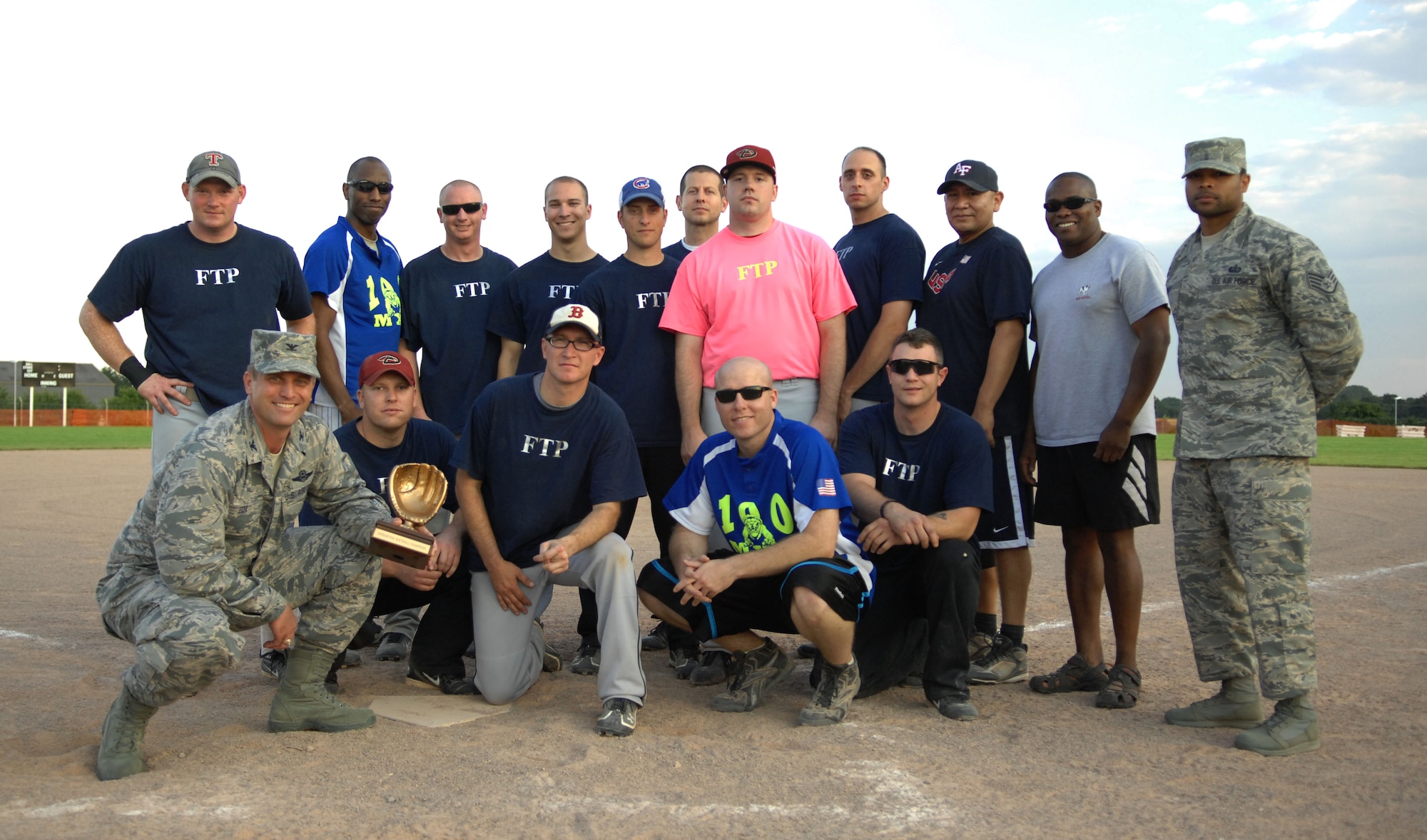 U.S. Air Force Col. David Cox, 100th Air Refueling Wing vice commander, bottom left, presents the championship trophy to the 100th Maintenance Group softball team following the intramural softball championship game between the 100th MXG and the 100th Operations Group Aug. 1, 2013, on RAF Mildenhall, England. The 100th MXG scored 15 unanswered runs in the second game of the championship, securing the championship trophy. (U.S. Air Force photo by Airman 1st Class Dillon Johnston/Released)