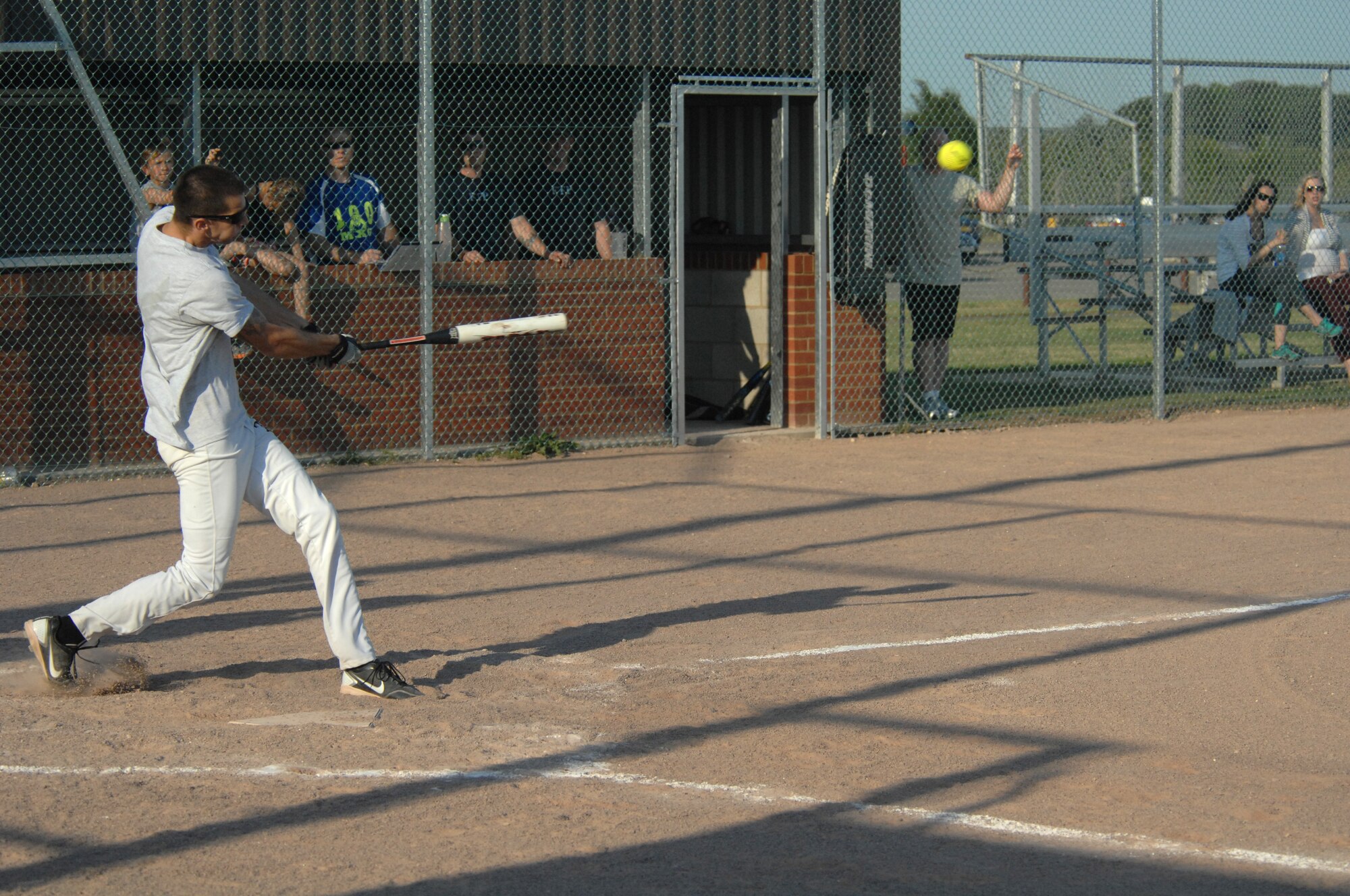 U.S. Air Force Airman 1st Class Brian Brock, 100th Operations Group softball team member, crushes the ball into center field Aug. 1, 2013, during the intramural softball championship game between the 100th Maintenance Group and the 100th OG on RAF Mildenhall, England. To win the championship, the 100th MXG had to win two games in one night. (U.S. Air Force photo by Airman 1st Class Dillon Johnston/Released)