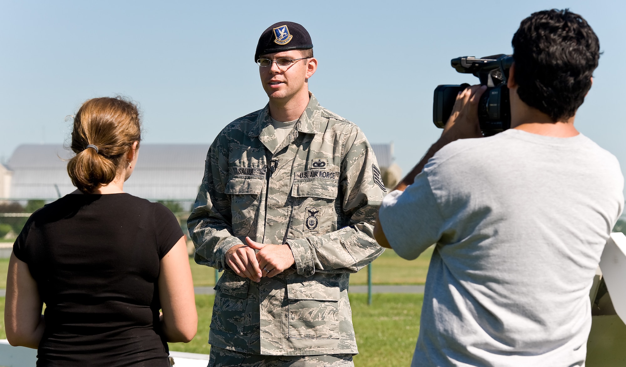 Tech. Sgt. Matthew Salter, military working dog kennel master with the 436th Security Forces Squadron, talks with Ashley Barnas, a reporter with The News Journal, Wilmington, Del. during an interview July 30, 2013, at Dover Air Force Base, Del. Salter, along with MWD trainers and handlers, put on a training demonstration for The News Journal. (U.S. Air Force photo/Roland Balik)