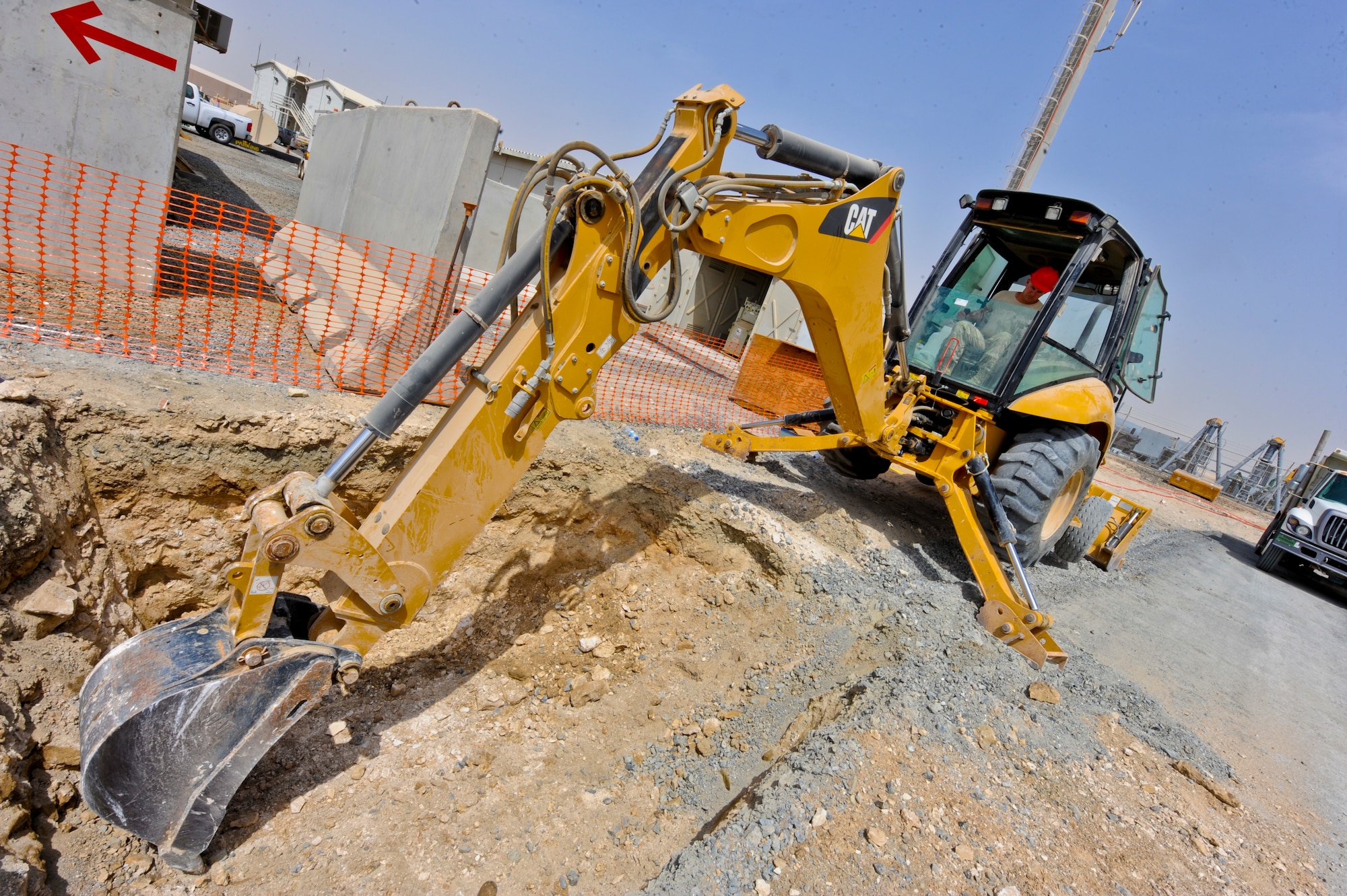 U.S. Air Force Senior Airman Justin Olthoff, 557th Expeditionary RED HORSE Squadron heavy equipment operator, uses a back-hoe to dig up land at an undisclosed location in Southwest Asia. The RED HORSE squadron consists of all the crafts needed to build buildings from the ground up. Olthoff is native to Great Falls, Mont., and is deployed from Malmstrom Air Force Base, Mont. (U.S. Air Force photo by Staff Sgt. Joshua J. Garcia) 