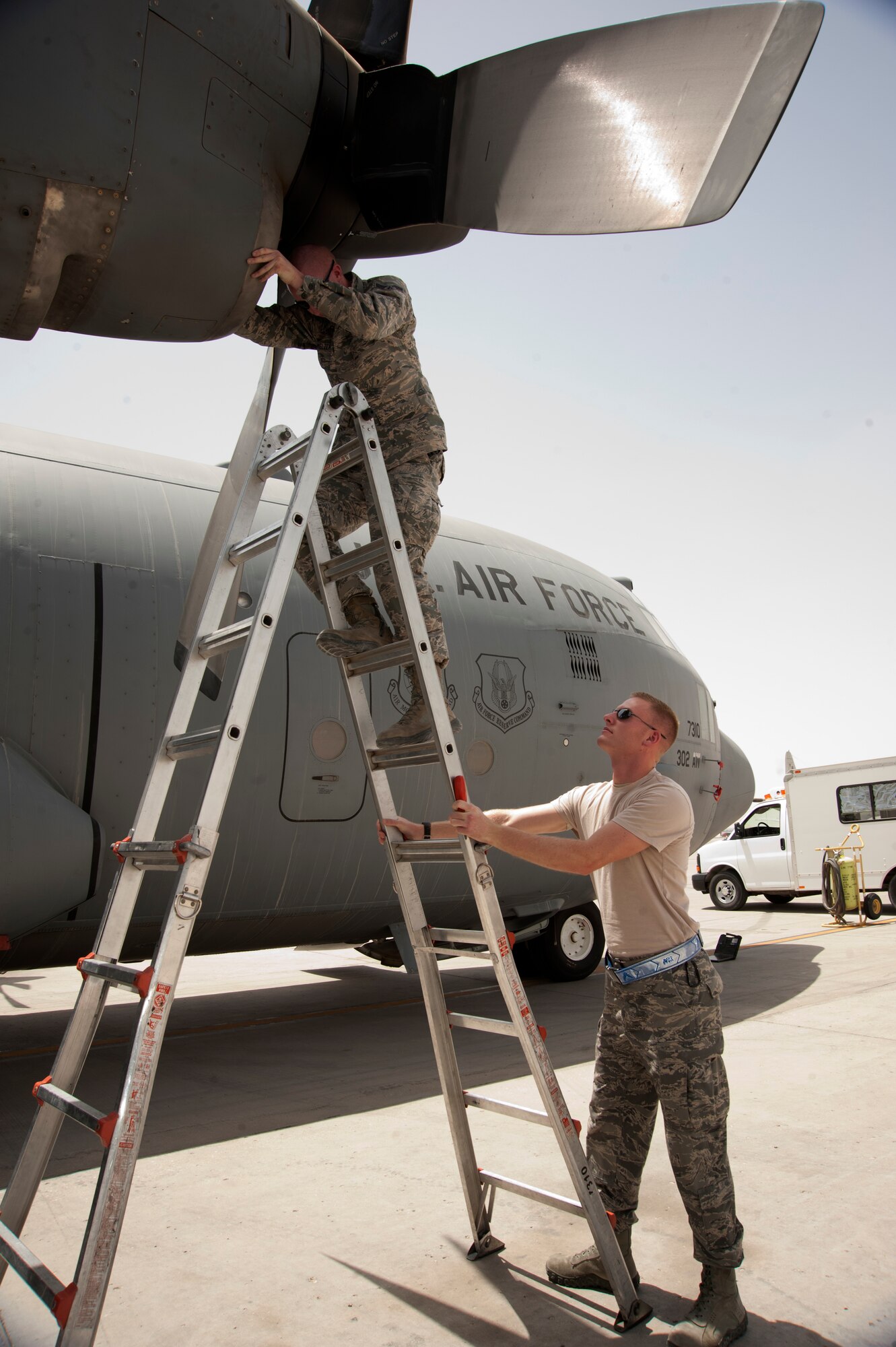 Senior Airman Aaron Battreal holds a ladder as Airman 1st Class Andrew Schmelzer inspects an engine intake during a C-130 Hercules preflight check at the 379th Air Expeditionary Wing in Southwest Asia, July 31, 2013. Battreal is a 746th Expeditionary Aircraft Maintenance Unit guidance and control journeyman and Schmelzer is a 746th EAMU aerospace propulsion journeyman. Both are deployed from Peterson Air Force Base, Colo. (U.S. Air Force photo/Senior Airman Bahja J. Jones) 