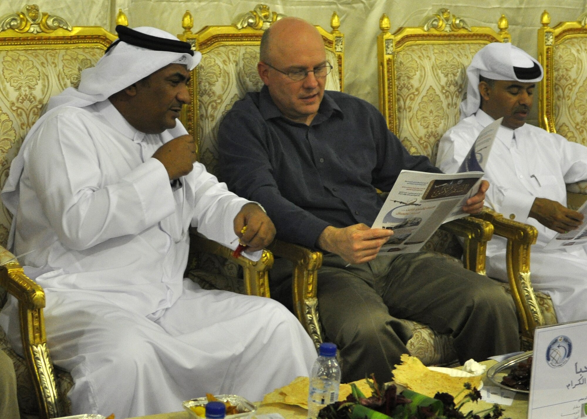 Col. David Lowe discusses an article with a local government official during a “Khaymah Ramadaniyyah” or Ramadan tent celebration hosted by local government officials near the 379th Air expeditionary Wing in Southwest Asia, July 24, 2013. The tent celebration is a late evening gathering with snacks that follows the breaking of the fast dinner during the Muslim holy month of Ramadan.  Lowe is the 379th AEW Host Nation Coordination Cell director deployed from the Pentagon in Arlington, Va. (U.S. Air Force photo/1st Lt. Susan Harrington)