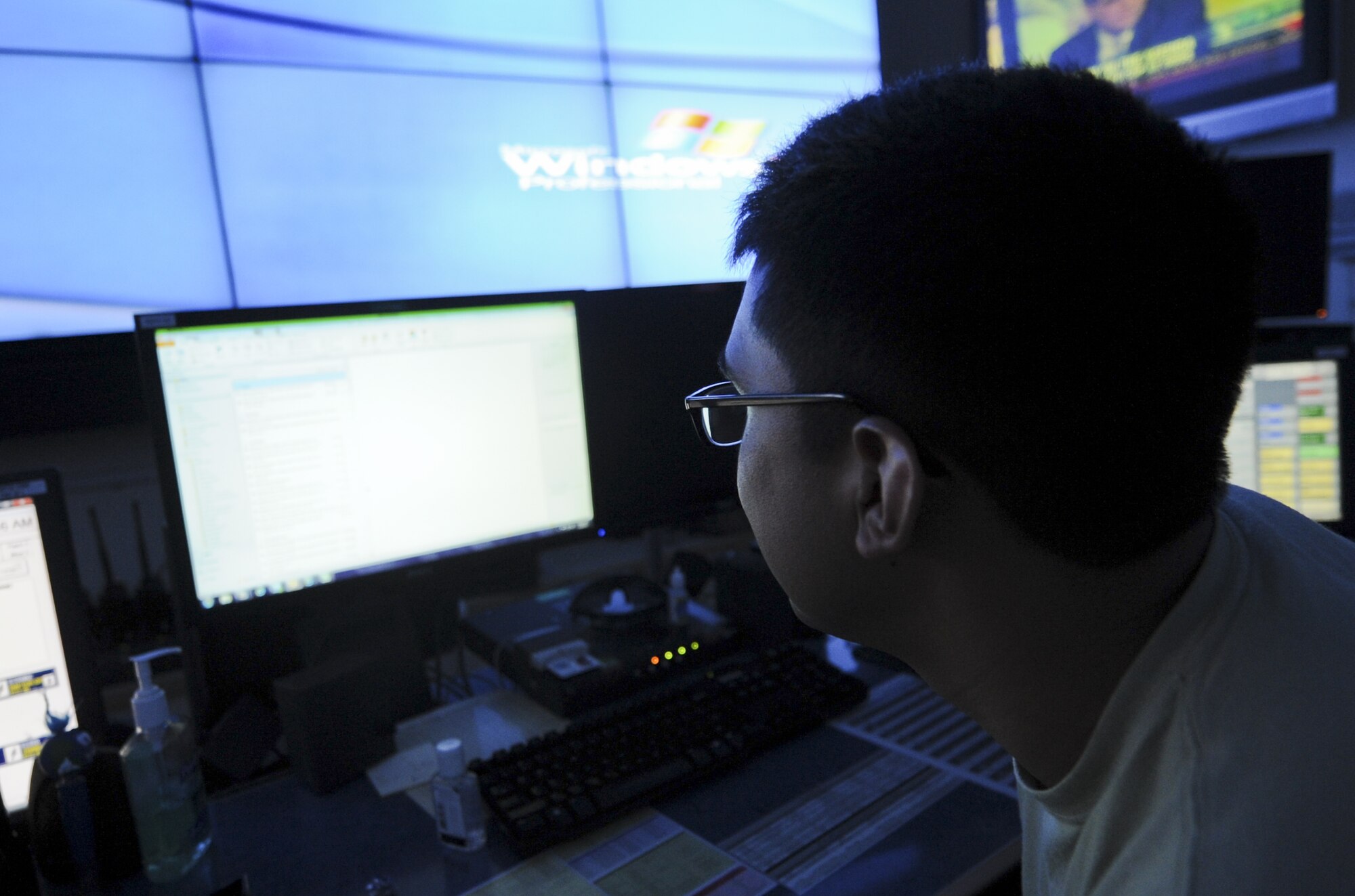 U.S. Air Force Airman 1st Class Steven Estrada, 380th Air Expeditionary Wing Command Post controller, monitors his many screens to keep an eye on base happenings at an undisclosed location in Southwest Asia July 30, 2013. The command post keeps the base connected and informed through various communications tools. Estrada calls Tucson, Arizona home and is deployed from Sheppard Air Force Base, Texas. (U.S. Air Force photo by Staff Sgt. Jacob Morgan)