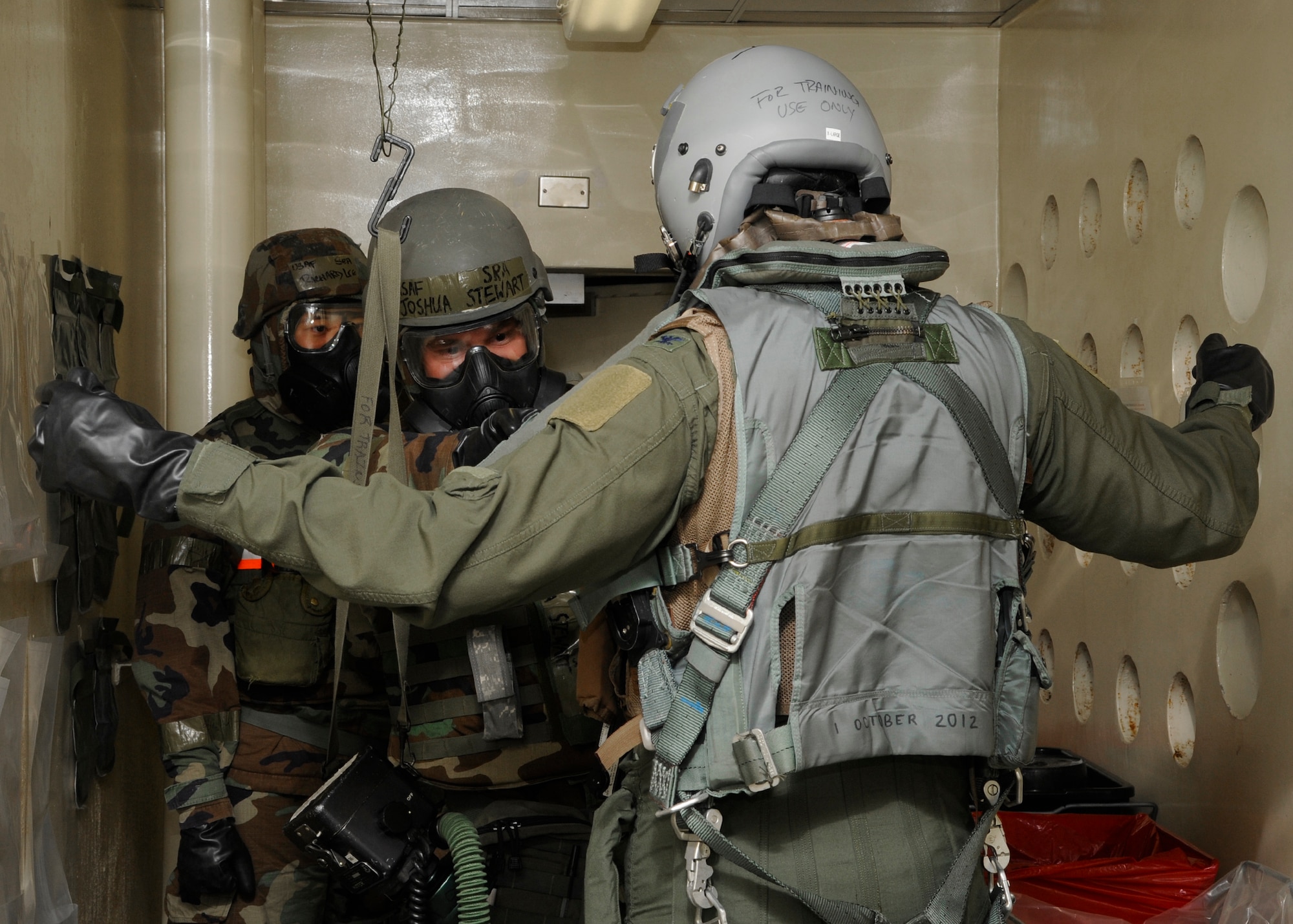 Senior Airmen Joshua Stewart and Richard Lee, 8th Operations Support Squadron aircrew flight equipment technicians, aid Col. S. Clinton Hinote, 8th Fighter Wing commander, through the aircrew decontamination station during a training session at Kunsan Air Base, Republic of Korea, July 27, 2013. AFE consistently trains to keep their skill sets sharp to ensure they are always ready for the fight. (U.S. Air Force photo by Staff Sgt. Jessica Haas/Released) 