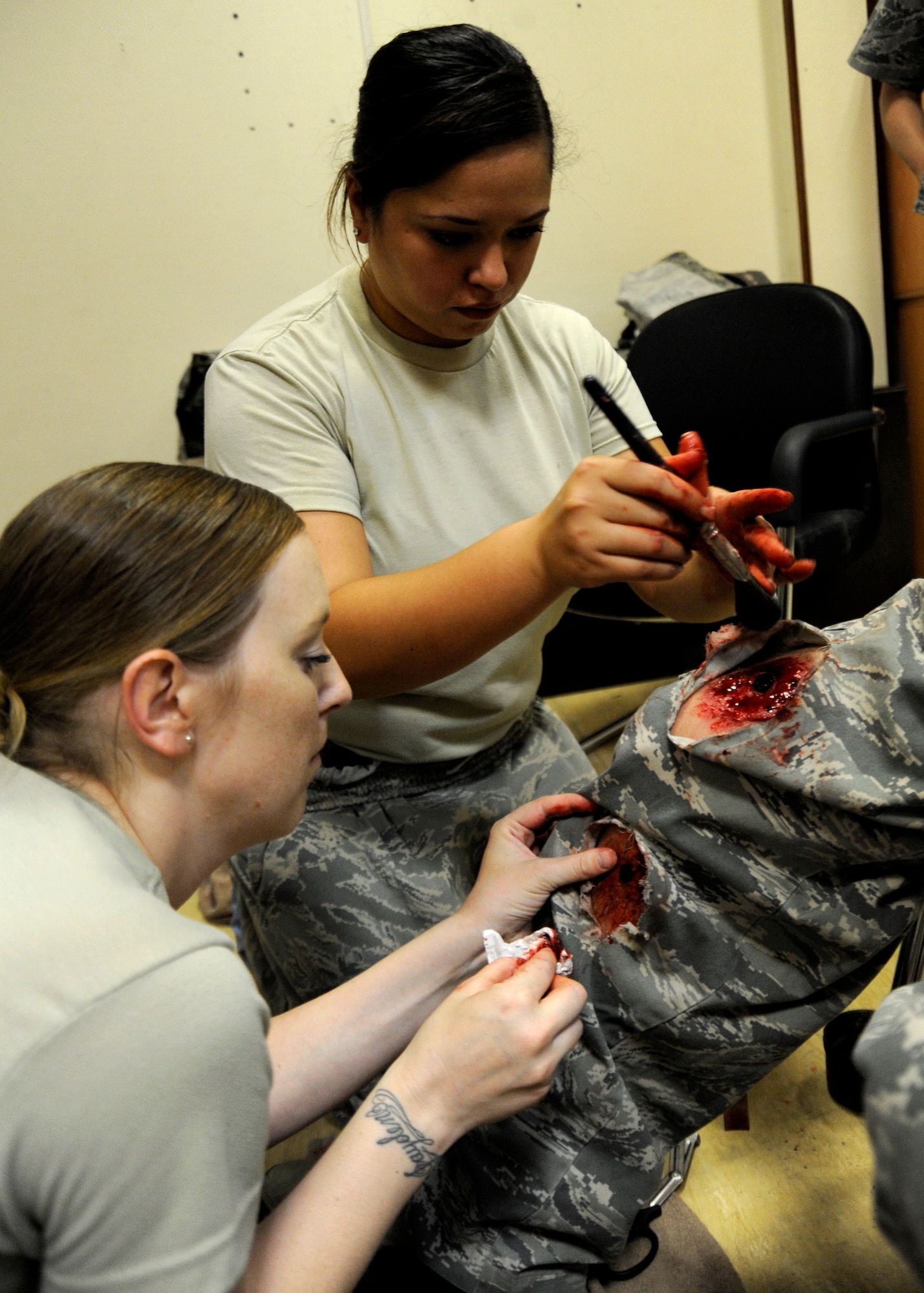 Staff Sgt. Jessica Wofford and Senior Airman Neileza Trinta-Santos apply a moulage to Col. Bryan Harris’ leg during a 379th Expeditionary Medical Group mass casualty exercise at the 379th Air Expeditionary Wing in Southwest Asia, July 26, 2013. Wofford is a 379th Medical Support Squadron ultrasound technician and Trinta-Santos is a 379th Expeditionary Medical Support Squadron Contingency Aeromedical Staging Facility health administration technician. Both are deployed from Joint Base Langley-Eustis, Va. (U.S. Air Force photo/Senior Airman Bahja J. Jones) 