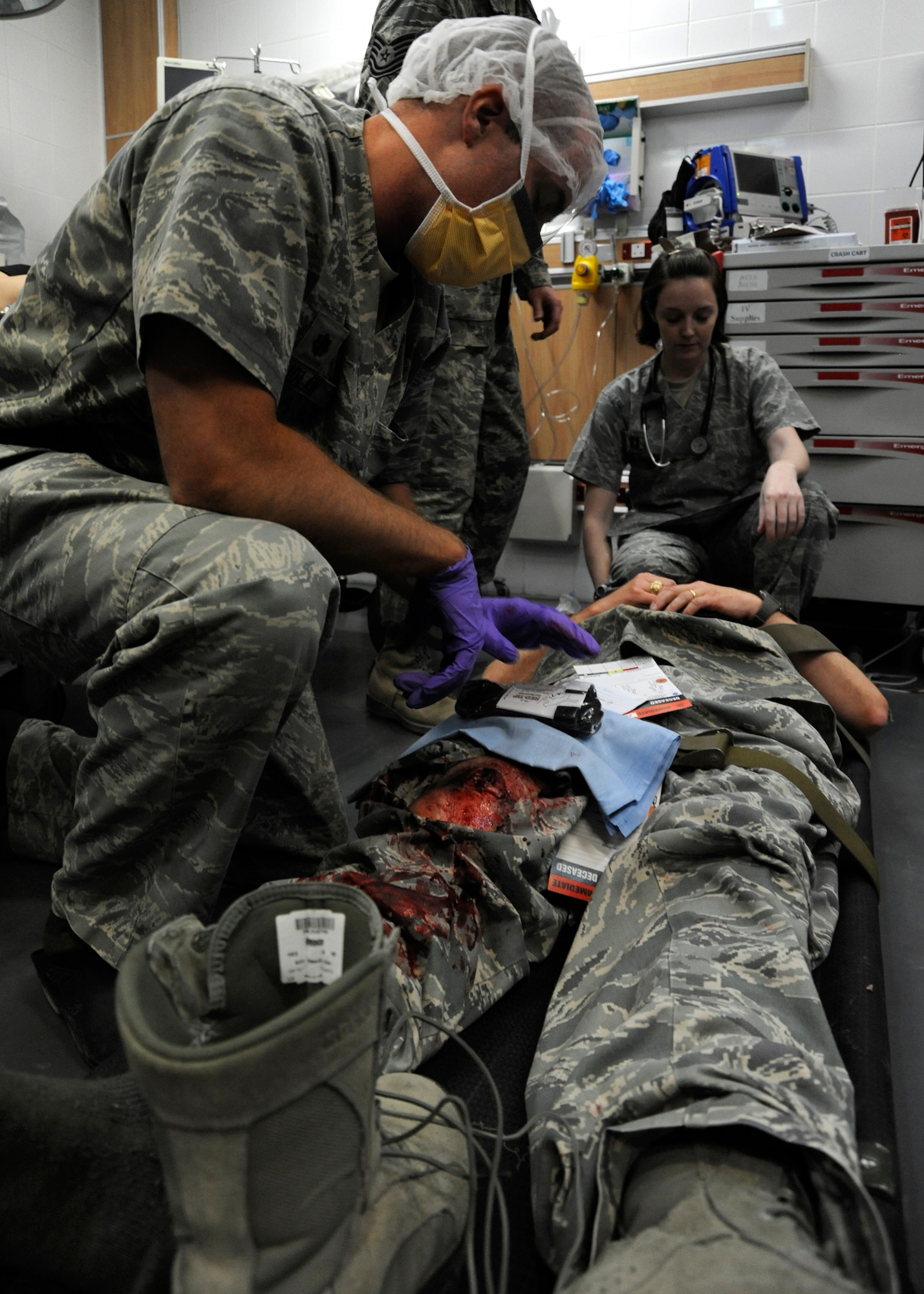 Maj. Michael Laidlaw and Capt. Joanna Slobodnjak assess the severity of Col. Bryan Harris’ mock injuries during a 379th Expeditionary Medical Group mass casualty exercise at the 379th Air Expeditionary Wing in Southwest Asia, July 26, 2013. Laidlaw is a 379th Expeditionary Medical Operations Squadron orthopedic surgeon deployed from Joint Base Langley-Eustis, Va., and Slobodnjak is a 379th EMDOS internal medicine doctor deployed from Joint Base Elmendorf-Richardson, Alaska. Harris is the 379th Expeditionary Maintenance Group commander. (U.S. Air Force photo/Senior Airman Bahja J. Jones) 
