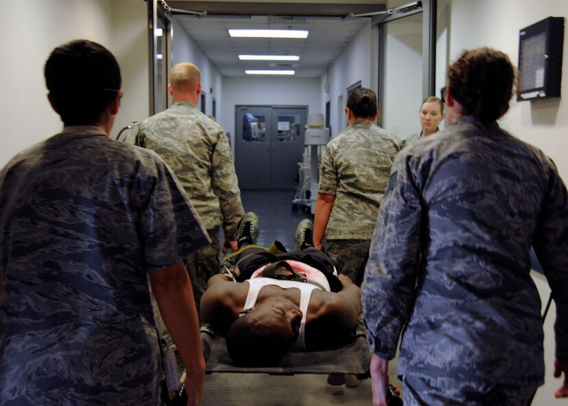 Four Airmen carry Senior Airman Ricky Smith into the hospital on a litter during a 379th Expeditionary Medical Group mass casualty exercise at the 379th Air Expeditionary Wing in Southwest Asia, July 26, 2013. The mass casualty exercise allowed the 379th EMDG to test their full medical response capabilities. Smith is a 379th Expeditionary Medical Support Squadron medical logistics technician deployed from Joint Base Langley-Eustis, Va. (U.S. Air Force photo/Senior Airman Bahja J. Jones) 
