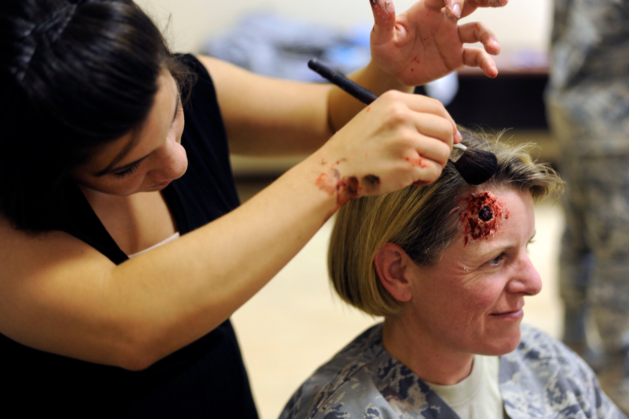 Col. Jennifer Fullmer receives a moulage of a gunshot wound by Senior Airman Natasha Ringlein during a 379th Expeditionary Medical Group mass casualty exercise at the 379th Air Expeditionary Wing in Southwest Asia, July 26, 2013. Fullmer is the 379th AEW vice commander and Ringlein is a 379th Expeditionary Medical Operations Support Squadron respiratory therapist deployed from Nellis Air Force Base, Nev. (U.S. Air Force photo/Senior Airman Bahja J. Jones) 