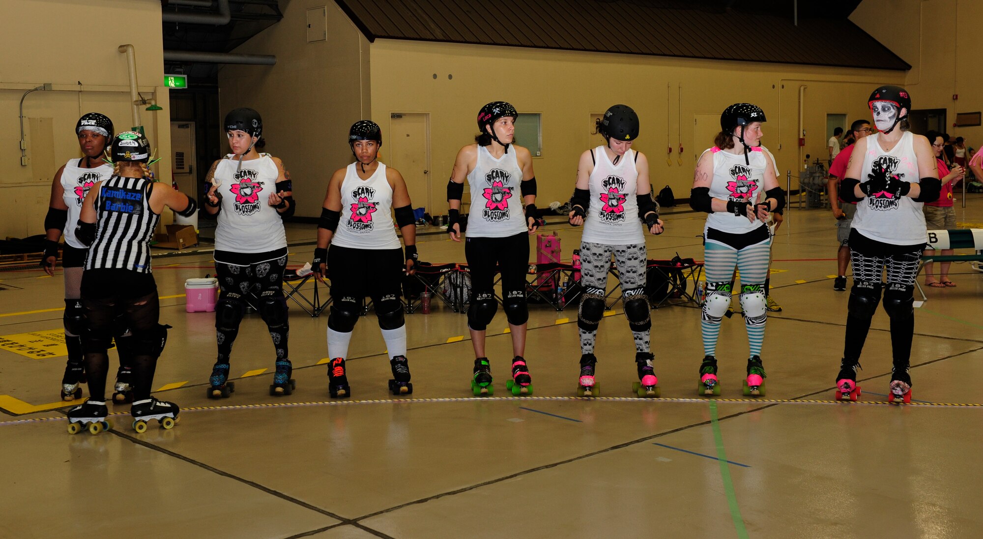 Members of the Skeletons stand in a line while a referee checks their equipment before the Scary Blossoms’ inner-team bout inside Hangar 15 at Yokota Air Base, Japan, July 27, 2013. The Scary Blossom members were split into two teams during their bout: the Skeletons and the Reapers. (U.S. Air Force photo by Senior Airman Michael Washburn)