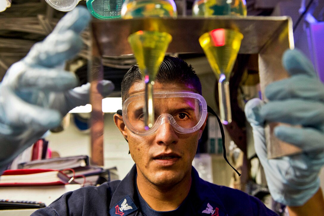 U.S. Navy Petty Officer 2nd Class Jose Alvarez inspects fuel samples for bottom sediment and water in the oil lab aboard the guided-missile destroyer USS Preble after refueling at sea with the Military Sealift Command fleet replenishment oiler USNS Yukon to support Talisman Saber 2013, an exercise in the Coral Sea, July 27, 2013. The biennial training exercise aims to improve Australian and U.S. combat readiness and interoperability. 