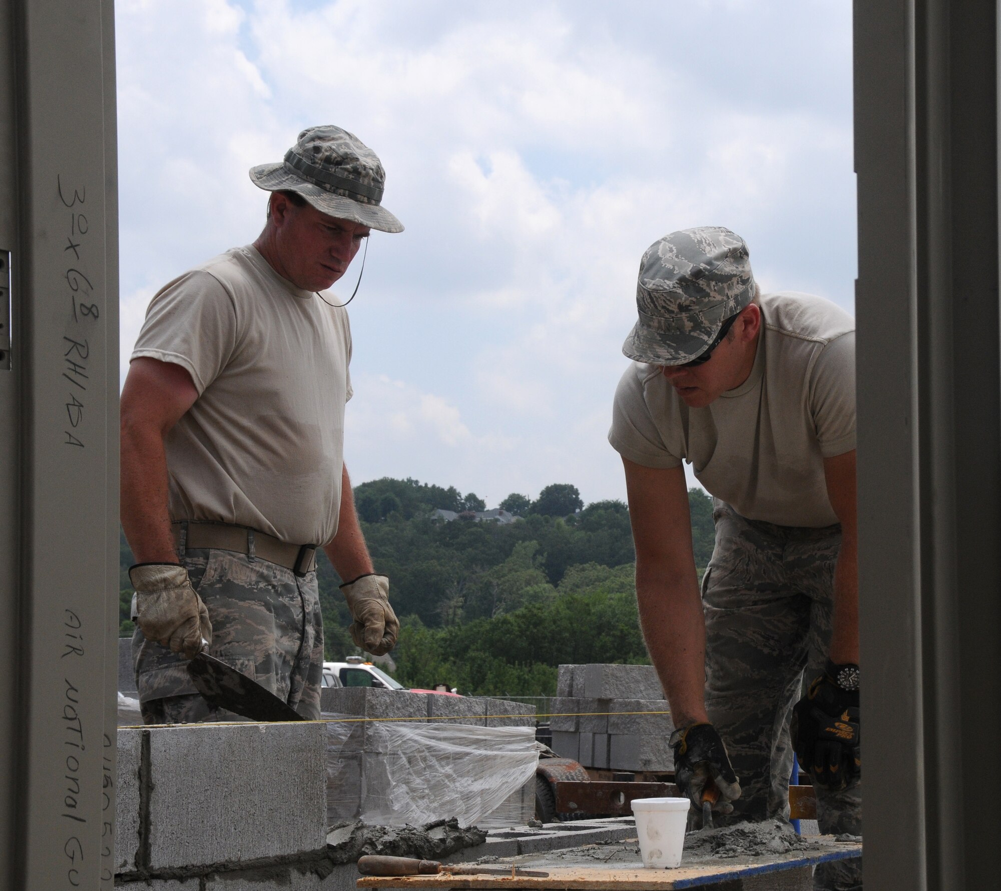 Airmen with the 188th Civil Engineering Squadron lay bricks for a new shower facility at the 188th's urban search and rescue training facility, July 15, 2013. (U.S. Air National Guard photo by Senior Airman John Hillier/188th Fighter Wing Public Affairs)