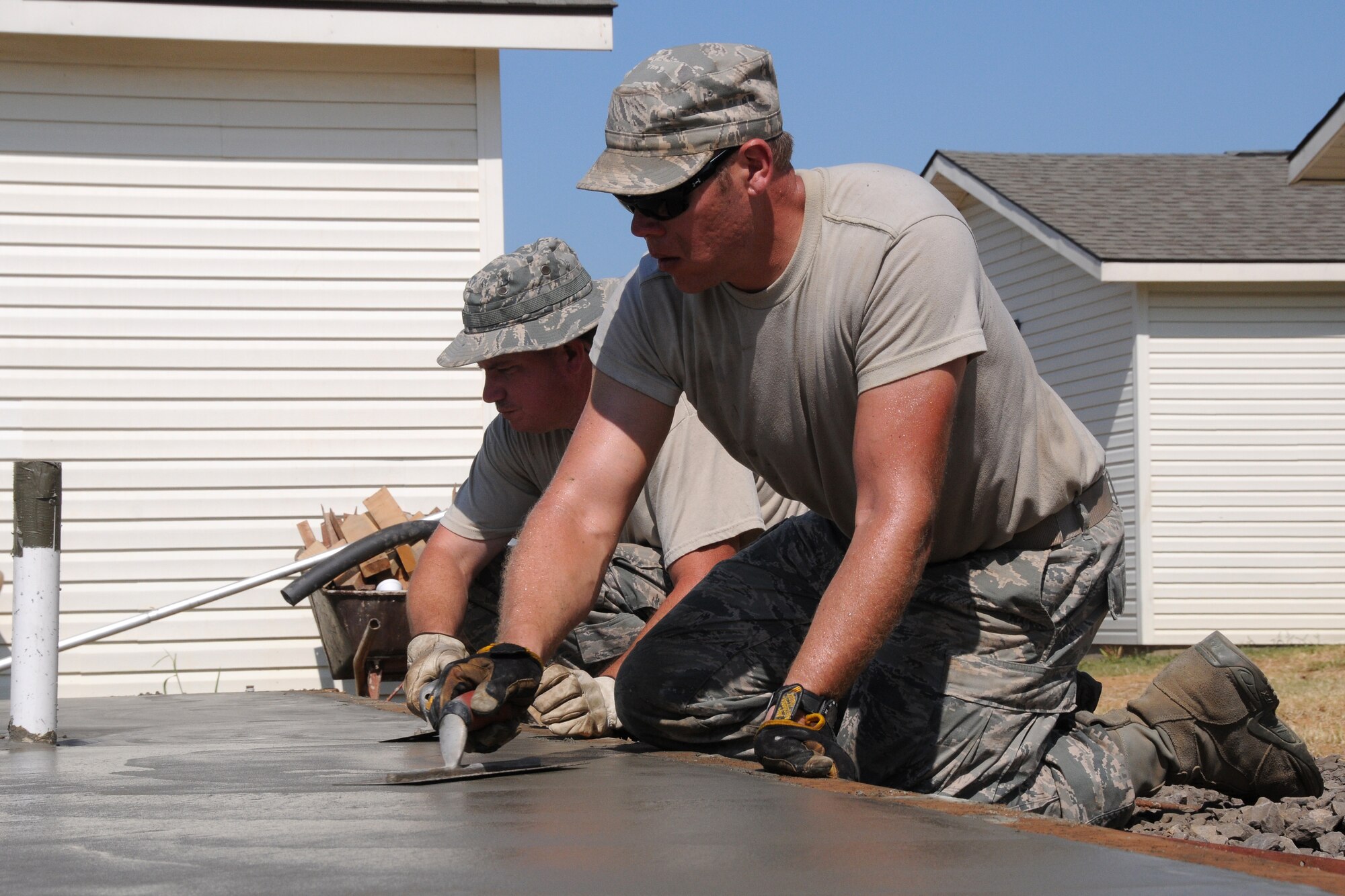188th Civil Engineering Squadron members smooth concrete for the foundation of a new shower facility at the 188th's urban search and rescue training site July 11, 2013. The new facility will allow the 188th to expand capacity at the site and conduct more training hours per day. (U.S. Air National Guard photo by Senior Airman John Hillier/188th Fighter Wing Public Affairs)