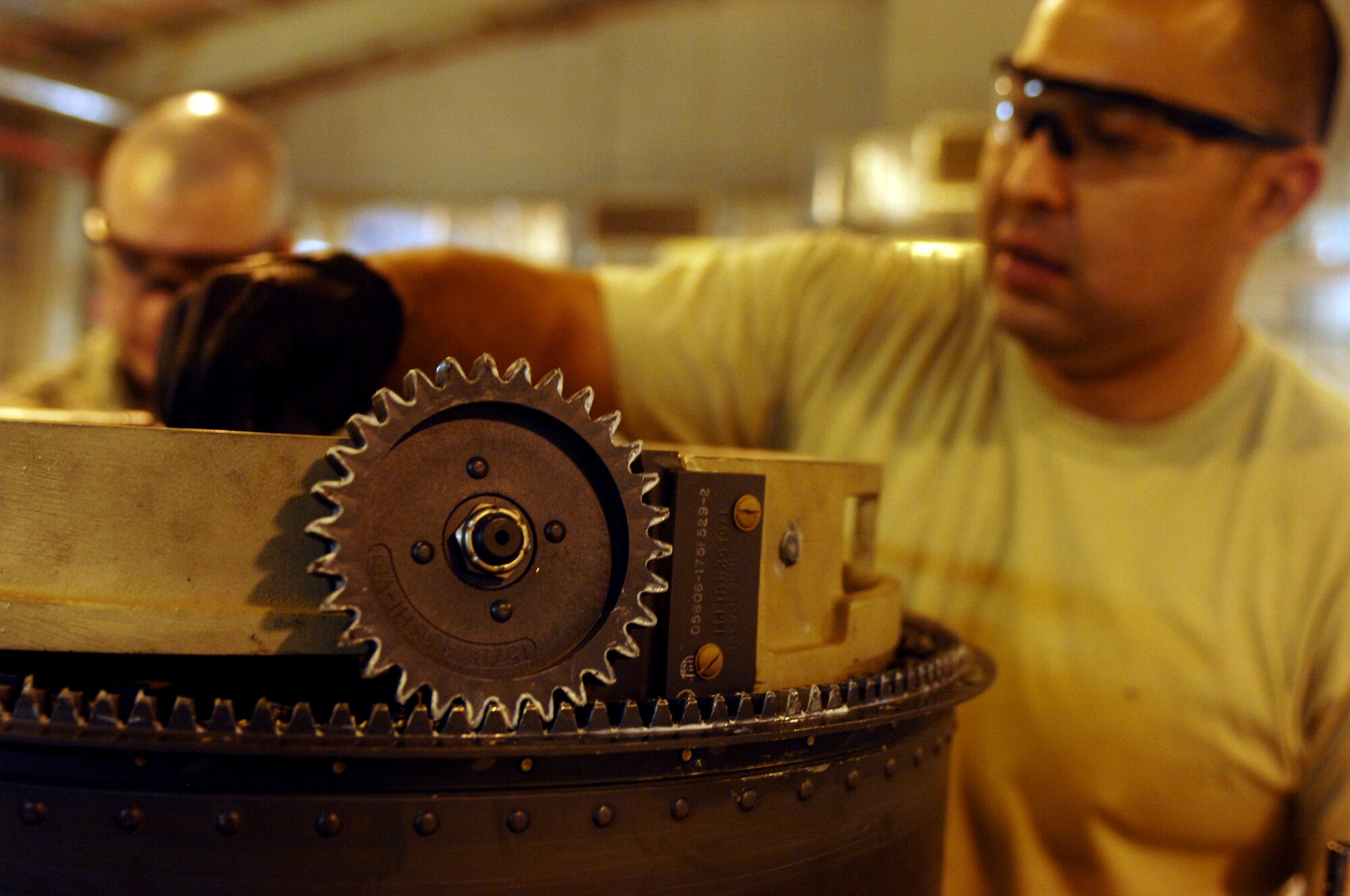 Airman 1st Class Brandon Anderson (Left), 451st Expeditionary Maintenance Squadron armament back shop combat technician, and Staff Sgt. Eduardo Sera (right), 451st Expeditionary Maintenance Squadron armament back shop floor chief disassemble part of an F-16 Fighting Falcon weapons system at Kandahar Airfield, Afghanistan July 25, 2013. Disassembly of the intricate weapons systems of aircraft is necessary in order for cleaning, repairs and lubrication. Anderson and Sera are stationed at Spangdahlem Air Base, Germany, and Anderson is a native of Asheville, N.C. (U.S. Air Force photo by Senior Airman Jack Sanders)