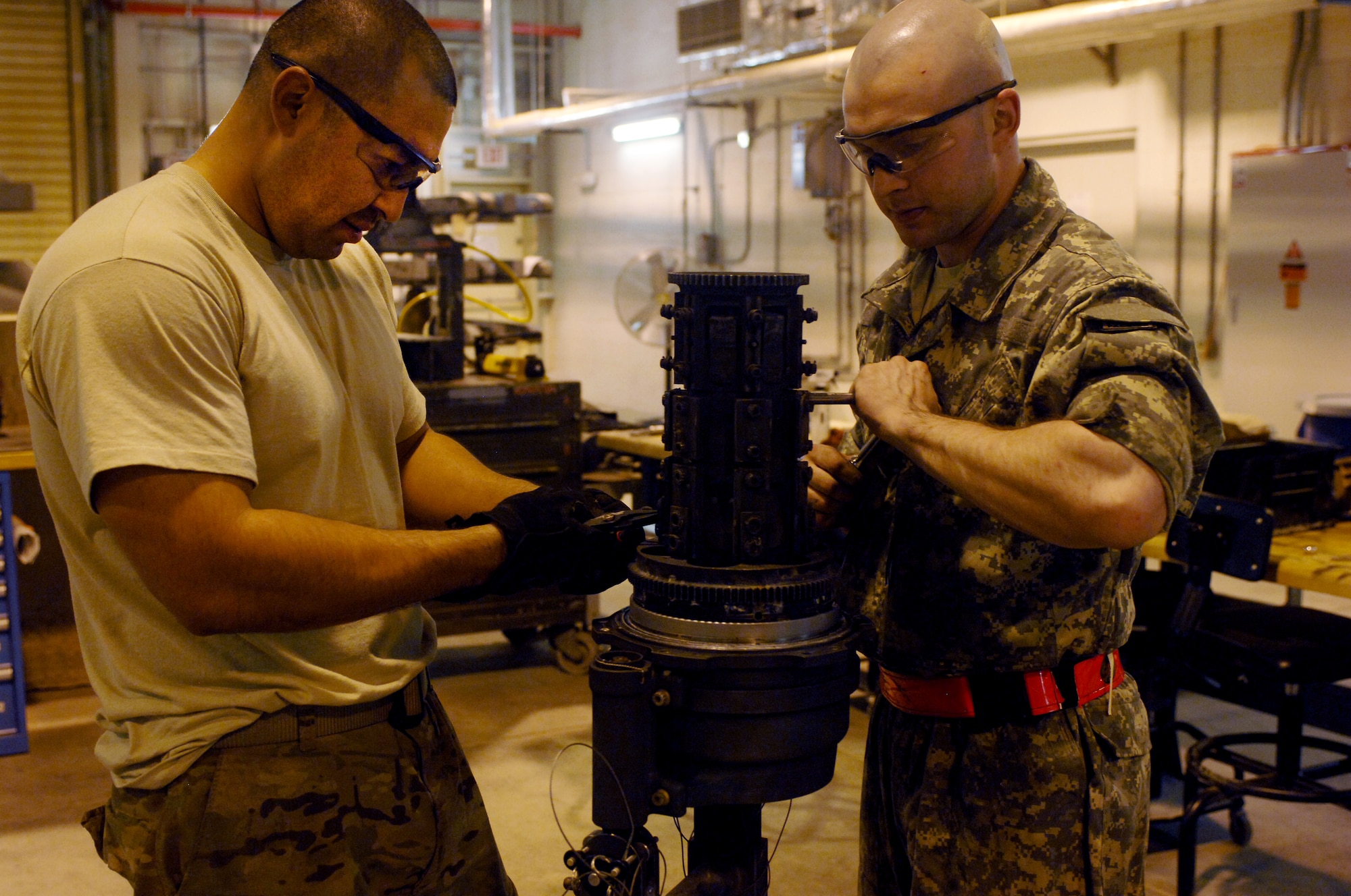 Staff Sgt. Eduardo Sera (left), 451st Expeditionary Maintenance Squadron armament back shop floor chief and Airman 1st Class Brandon Anderson (right), 451st Expeditionary Maintenance Squadron armament back shop combat technician, dissemble part of an F-16 Fighting Falcon weapons system at Kandahar Airfield, Afghanistan, July 25, 2013. Regular maintenance on aircraft weapons systems enables the wing to meet the air tasking order and provide close air support to NATO forces throughout Afghanistan. Anderson and Sera are stationed at Spangdahlem Air Base, Germany, and Anderson is a native of Asheville, N.C. (U.S. Air Force photo by Senior Airman Jack Sanders)