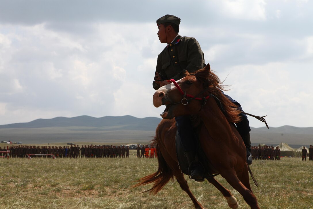 A soldier with 234 Cavalry Unit, Mongolian Armed Forces, performs for an international delegation during the opening ceremony for exercise Khaan Quest 2013, Aug. 3. Approximately 1,000 service members from 13 different nations are participating in Khaan Quest 2013, which consists of a command post exercise (CPX) and field training exercise (FTX) at Five Hills Training Area, both focusing on peacekeeping and stability operations. Mongolian and U.S. armed forces, along with other regional partners, will also participate in Engineering Civic Action Program (ENCAP) projects, as well as Cooperative Health Engagement (CHE) events in Ulaanbaatar, enhancing joint Mongolian-U.S. medical and engineering capabilities and providing outreach to underserved communities.