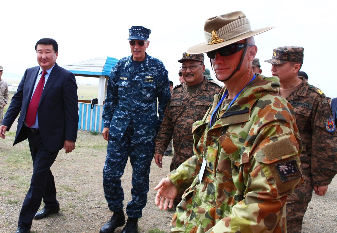 Australian Army Maj. Paul Manoel, operations officer for U.S. forces during Khaan Quest 2013, leads Mongolian and U.S. military leadership into the exercise command operations center, Aug. 3. Approximately 1,000 service members from 13 different nations are participating in Khaan Quest 2013, which consists of a command post exercise (CPX) and field training exercise (FTX) at Five Hills Training Area, both focusing on peacekeeping and stability operations. Mongolian and U.S. armed forces, along with other regional partners, will also participate in Engineering Civic Action Program (ENCAP) projects, as well as Cooperative Health Engagement (CHE) events in Ulaanbaatar, enhancing joint Mongolian-U.S. medical and engineering capabilities and providing outreach to underserved communities.