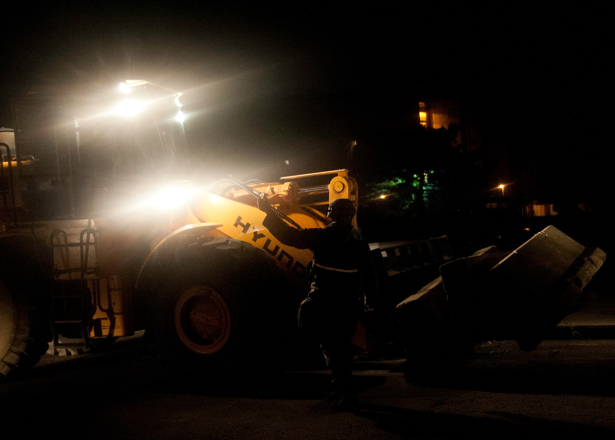 Staff Sgt. Maxwell Evans, 8th Civil Engineer Squadron pavement and heavy equipment technician, signals to the fork lift driver the delivery point for protective barricades during exercise Beverly Midnight 13-3 at  Kunsan Air Base, Republic of Korea, Aug. 5, 2013. Evans and 8th CES personnel enhanced base security during the base exercise by positioning barriers in strategic locations. (U.S. Air Force photo by Senior Airman Clayton Lenhardt/Released) 