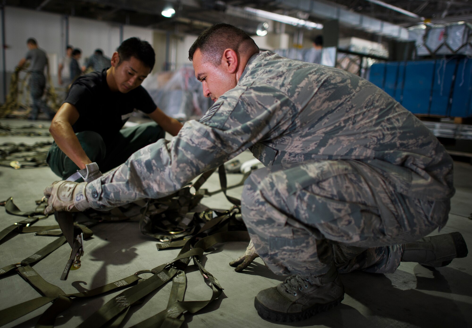 YOKOTA AIR BASE, Japan -- Tech. Sgt. Noe Navarro, 374th Logistics Readiness Squadron assistant NCO in Charge of cargo movement, assists a Japan Air Self-Defense Force member sorting tie downs to be used on several pallets heading to Alaska in support of Red Flag-Alaska at Yokota Air Base, Japan, Aug. 2, 2013. Red Flag-Alaska is an air-combat exercise designed to provide a realistic training environment. (U.S. Air Force photo by Staff Sgt. Chad C. Strohmeyer)