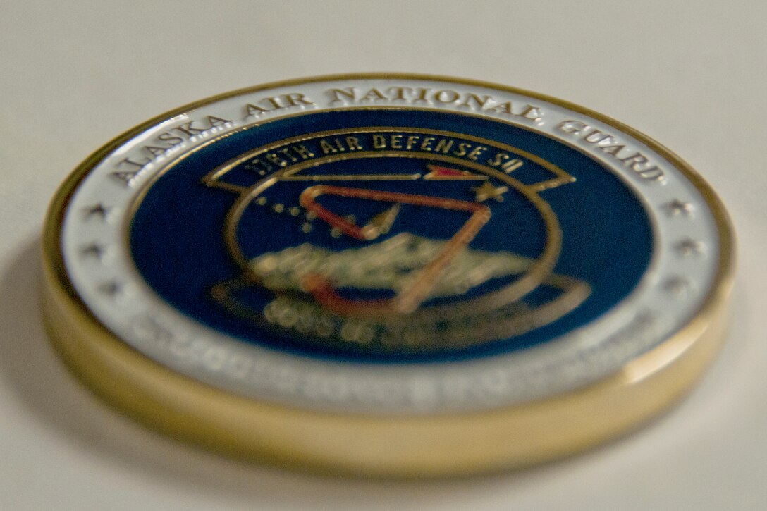 JOINT BASE ELMENDORF-RICHARDSON, Alaska -- Displayed is a new 176th Air Defense Squadron coin. The 176th Air Control Squadron was re-designated to the 176th Air Defense Squadron during a ceremony here Aug. 3. U.S. National Guard photo by Staff Sgt N. Alicia Halla/ Released