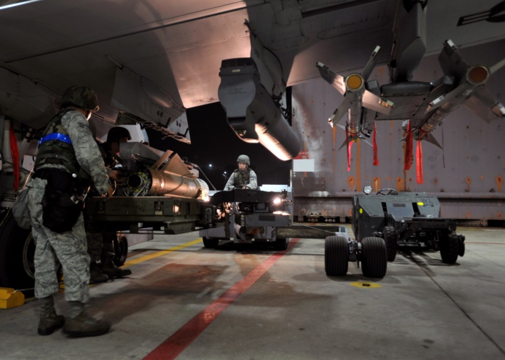 Weapons loaders from the 51st Aircraft Maintenance Squadron place a bomb on an A-10 Thunderbolt during the start of Beverly Midnight 13-03 at Osan Air Base, Republic of Korea, August 5, 2013. The exercise highlights Osan Airmen’s ability to position, employ and sustain forces, and showcase operational readiness. (U.S. Air Force photo/Senior Airman Siuta B. Ika)