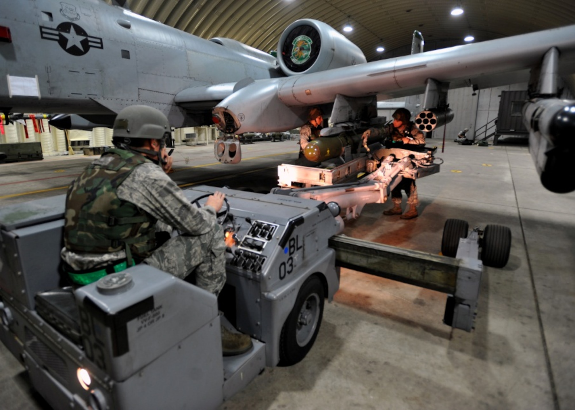 Weapons loaders from the 51st Aircraft Maintenance Squadron place a bomb on an A-10 Thunderbolt during the start of Beverly Midnight 13-03 at Osan Air Base, Republic of Korea, August 5, 2013. Osan is in the fourth simulated wartime contingency exercise executed in 2013 that tests the base's ability to defend and execute the mission in a heightened state of readiness. (U.S. Air Force photo/Senior Airman Siuta B. Ika)