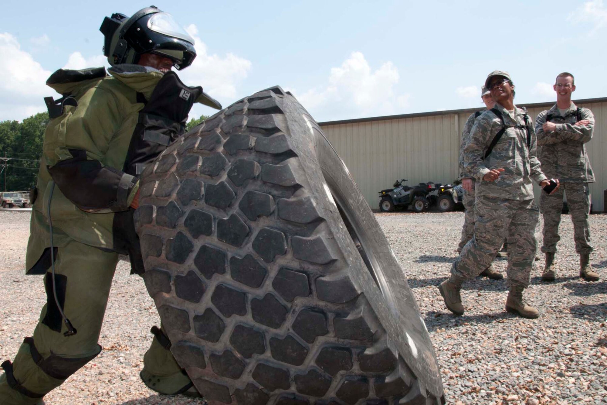 U.S. Air Force Chaplain Candidate 2nd Lt. Isaiah Marshall flips a tire while wearing a protective suit during a visit to the 2nd Bomb Wing Explosive Ordnance Disposal unit at Barksdale Air Force Base, La., Aug. 2, 2013.  The exercise was designed to help the candidates gain a better understanding of the training EOD members undergo in their job.  More importantly, the candidates received insight from the members on the importance of visitation in forward deployed locations.  The EOD members stressed the idea that simply having a chaplain present to them in such dangerous environment offered a degree of comfort.  (U.S. Air Force photo by Tech. Sgt. Ted Daigle/Released).