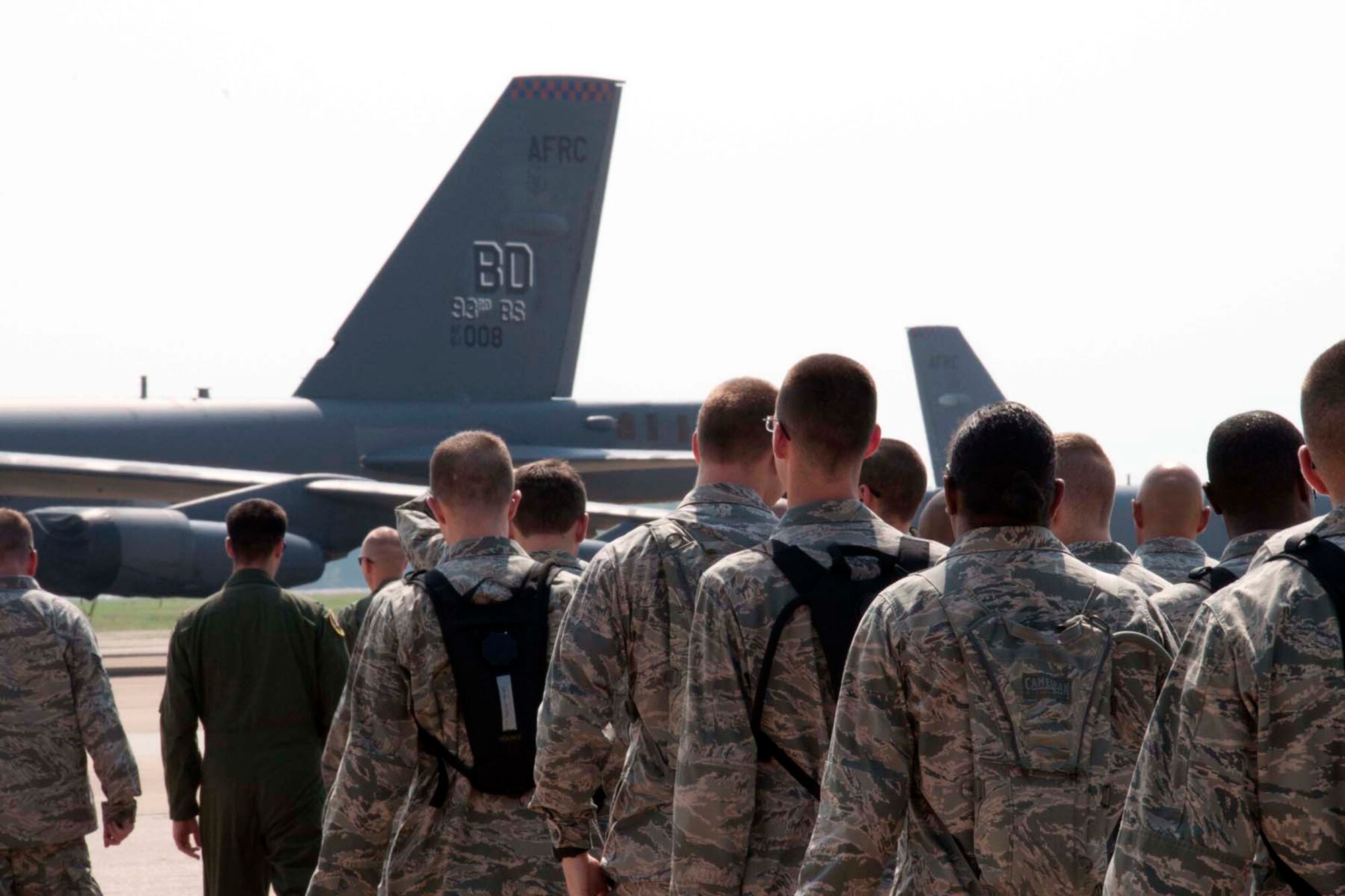 The tail of a B-52 Stratofortress looms large on the horizon as U.S. Air Force chaplain candidates, their cadre, and pilots of the 307th Bomb Wing arrive at the flightline at Barksdale Air Force Base, La., Aug. 2, 2013.  The candidates learned about the plane and listened to ideas on how to best meet the spiritual and spiritual needs of U.S. Air Force pilots.  In addition to talking to pilots, the candidates also spoke with members in several other jobs to gain perspective on their unique situations and needs. (U.S. Air Force photo by Tech. Sgt. Ted Daigle/Released)