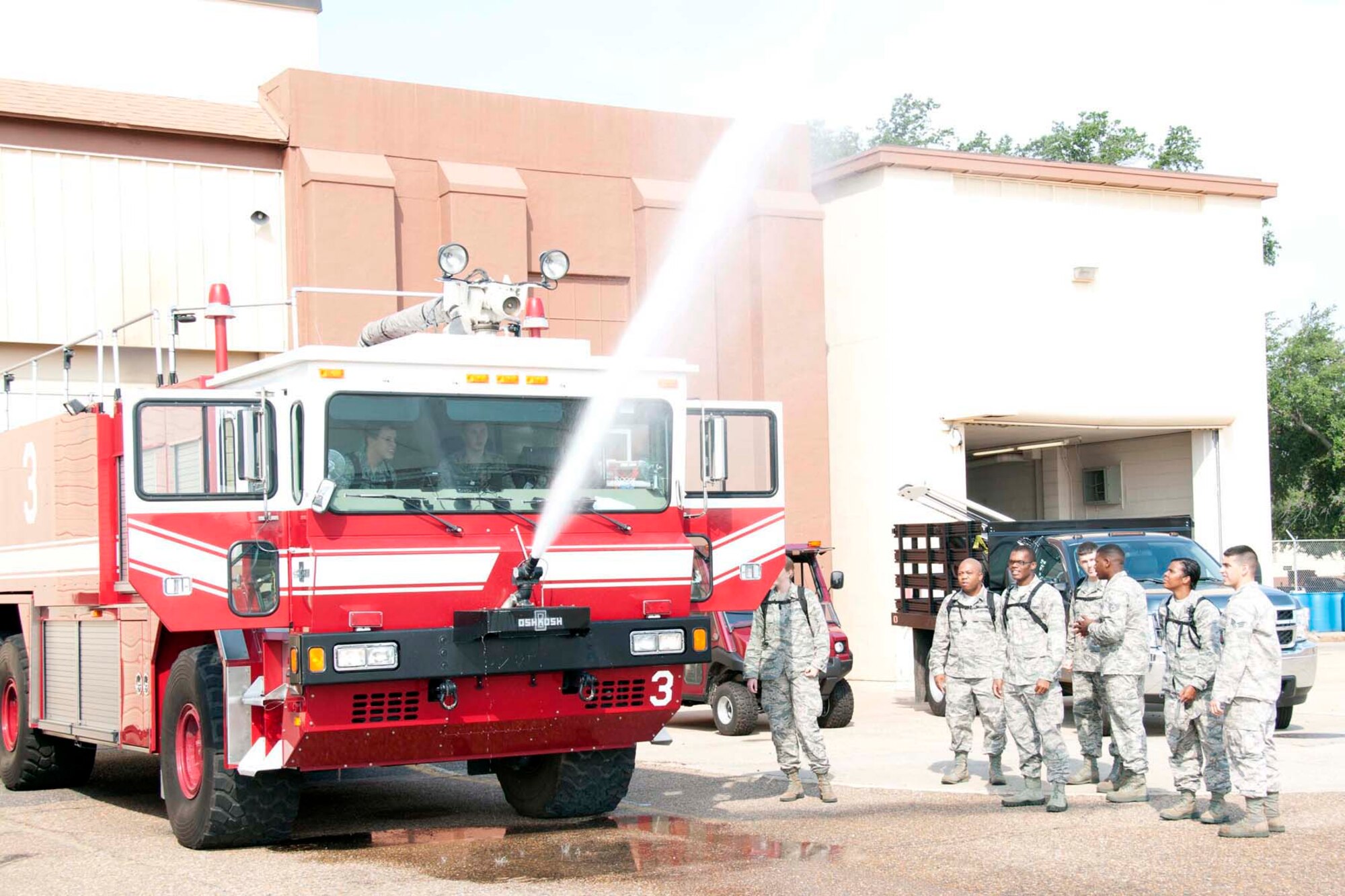 U.S. Air Force chaplain candidates test a water cannon on a fire truck at Barksdale Air Force Base, La. Aug. 2, 2013.  Barksdale was the second stop for the 27 candidates as part of the Chaplain Candidate Intensive Internship, a program designed to proved a structured opportunity for students to test their call and suitability for service as Air Force chaplains.  Through the program, the candidates get a broad overview of the Air Force and gain a better sense of how to serve its Airmen. (U.S. Air Force photo by Tech. Sgt. Ted Daigle/Released)