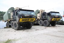 Soldiers with 502nd Multi Role Bridge Company, based at Fort Knox, Ky., park Logistics Vehicle Systems carrying Improvised Ribbon Bridges during a training exercise at Engineer Point aboard Camp Lejeune, N.C., July 30, 2013. Marines with Bridge Company, 8th Engineer Support Battalion, 2nd Marine Logistics Group worked with soldiers to build a continuous span across the water reaching more than 1,000 feet. 