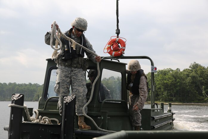 A Soldier with 502nd Multi Role Bridge Company, based at Fort Knox, Ky., gets ready to attach the MK III Bridge Erection Boat to an Improvised Ribbon Bridge during a training exercise at Engineer Point aboard Camp Lejeune, N.C., July 30, 2013. Marines with Bridge Company, 8th Engineer Support Battalion, 2nd Marine Logistics Group worked with soldiers and built together a continuous span across the water reaching more than 1,000 feet.