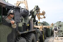 A Soldier with 502nd Multi Role Bridge Company, based at Fort Knox, Ky., gets ready to haul an Improvised Ribbon Bridge using a Logistics Vehicle System during a training exercise at Engineer Point aboard Camp Lejeune, N.C., July 30, 2013. Marines with Bridge Company, 8th Engineer Support Battalion, 2nd Marine Logistics Group worked with soldiers and used LVSs to place the IRBs in the water to build a continuous span across the water reaching more than 1,000 feet.